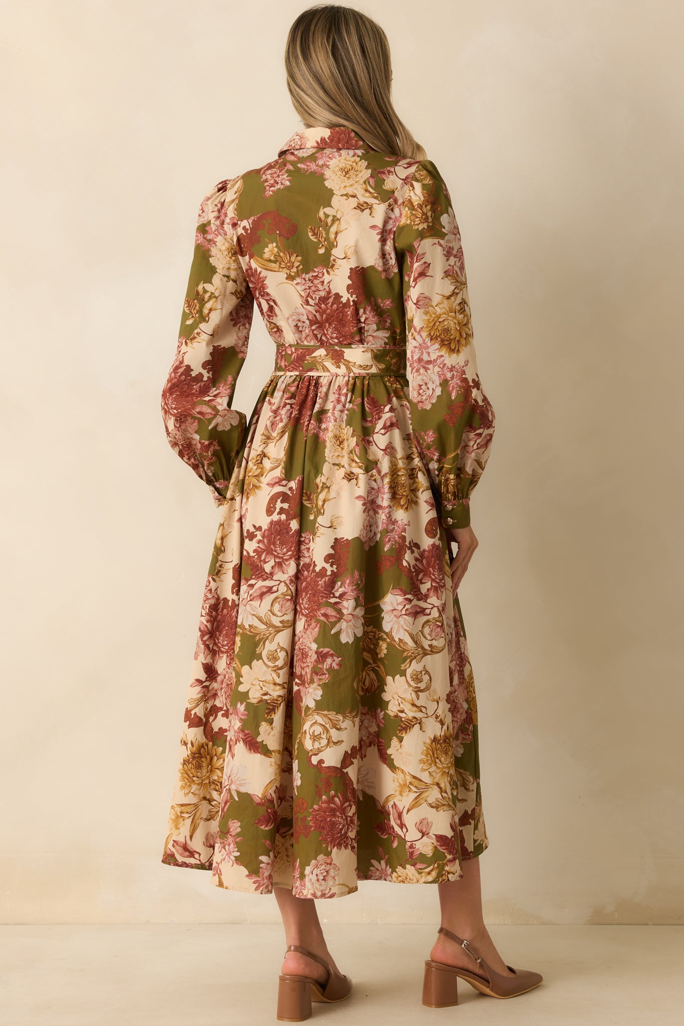 Rear view of the olive green floral dress, showing long puff sleeves, relaxed silhouette, and optional waist belt cinch.