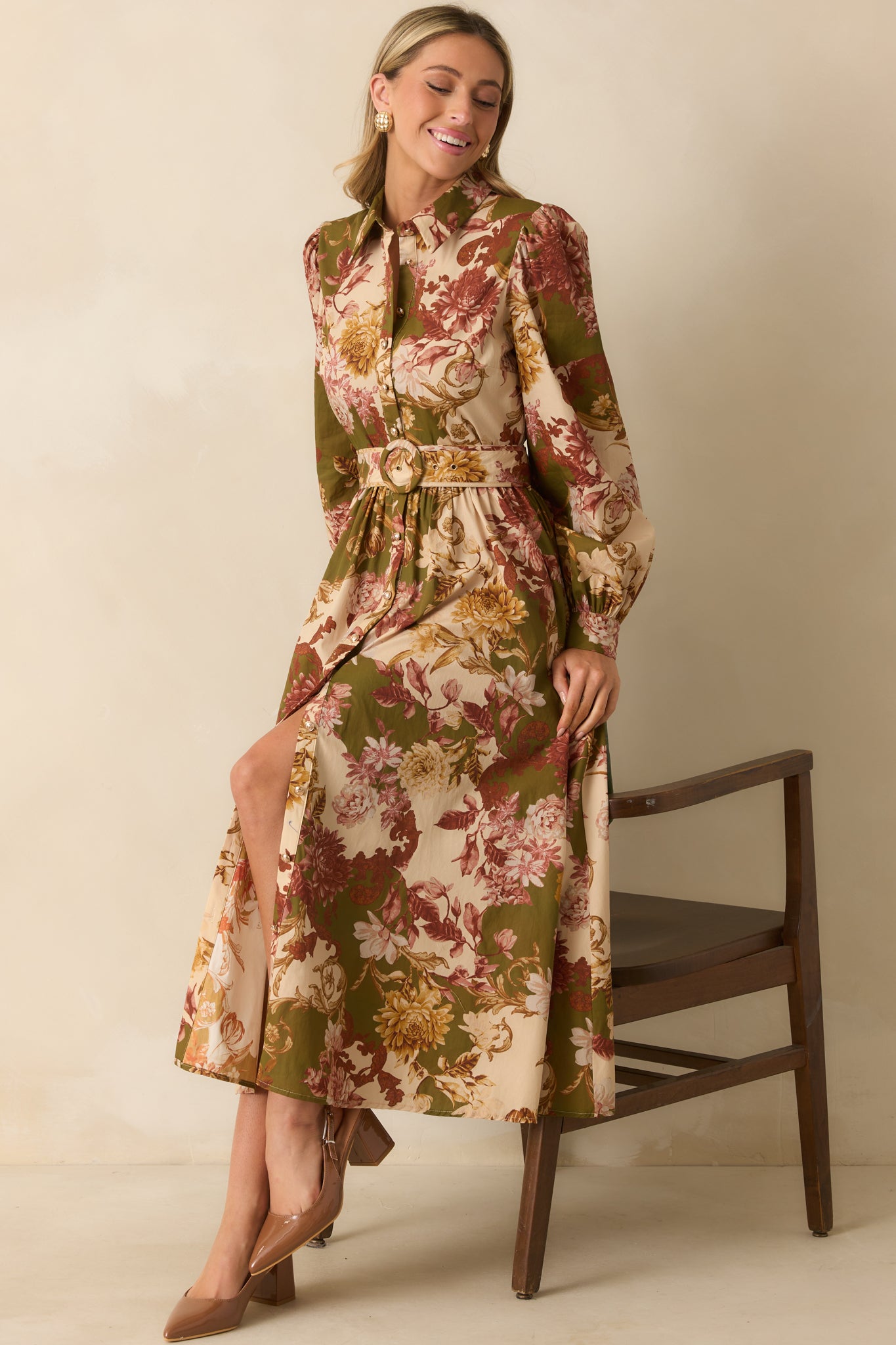 Full front view of the olive green multicolor floral dress, highlighting the buttoned cuffs, functional button front, and flowing silhouette.