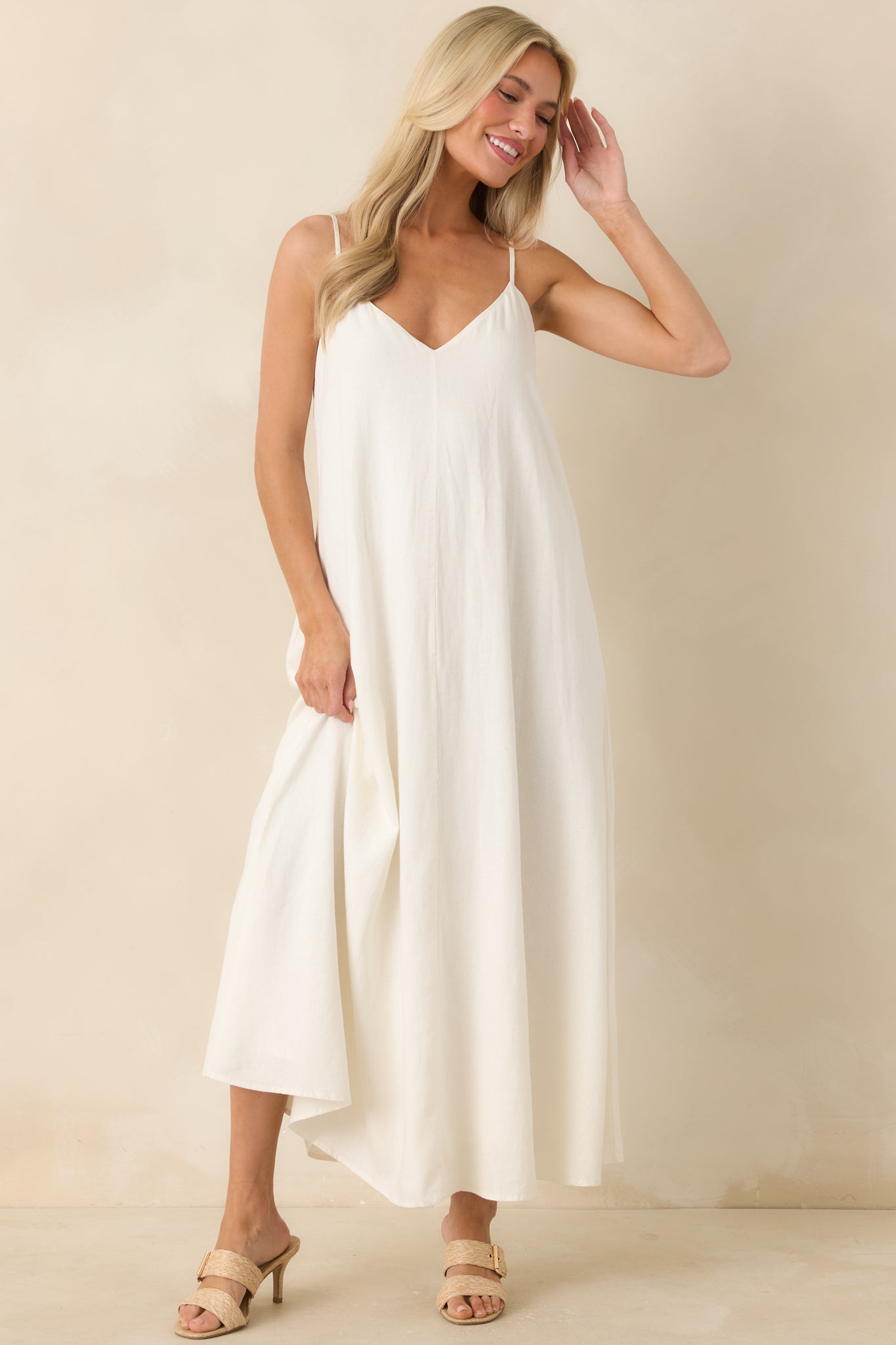 White linen blend midi dress featuring a v-neckline, adjustable spaghetti straps, and a relaxed flowy silhouette.