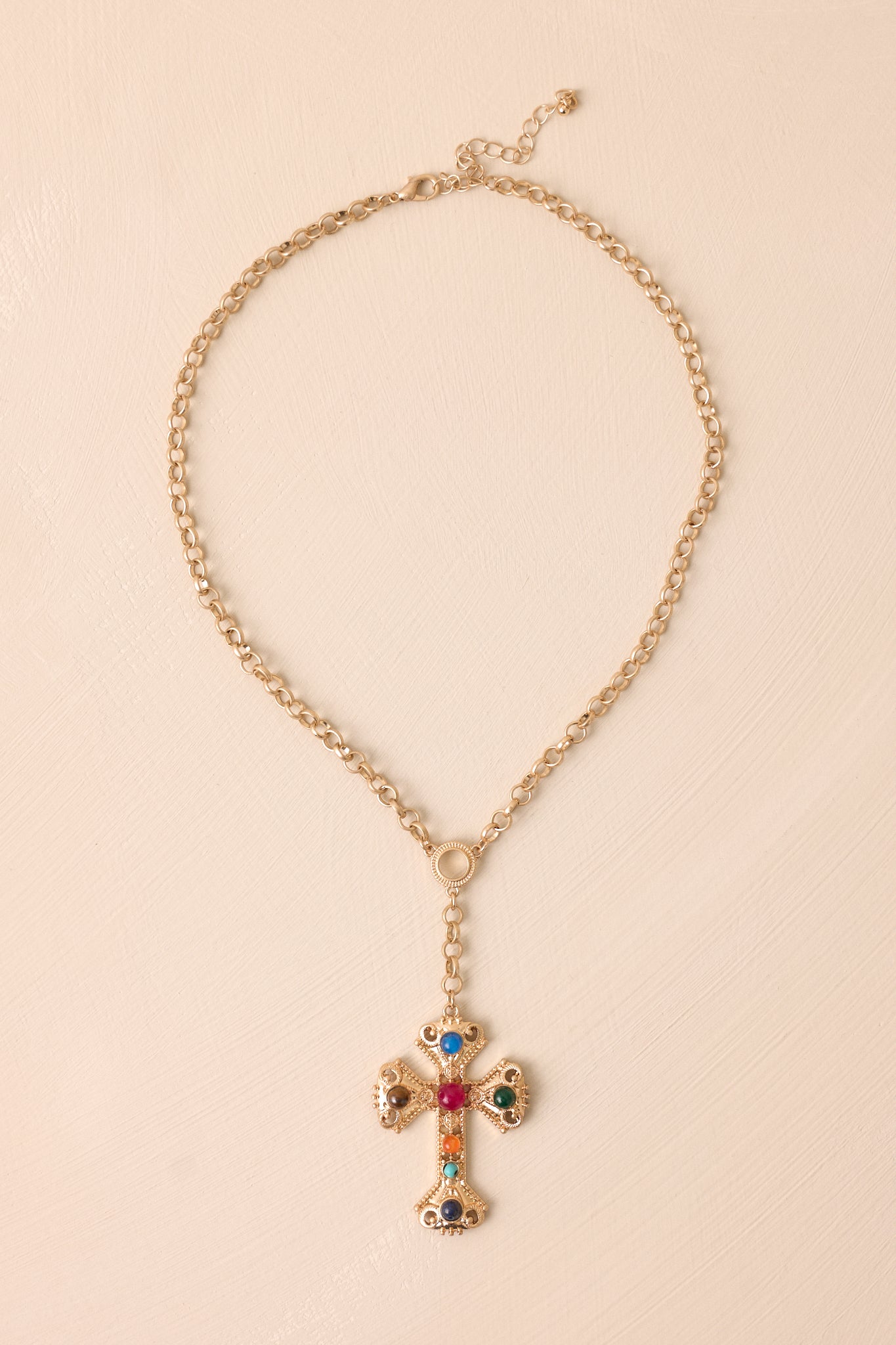 Close-up view of the gold chain of the necklace, highlighting its smooth texture and shine against a plain background.
