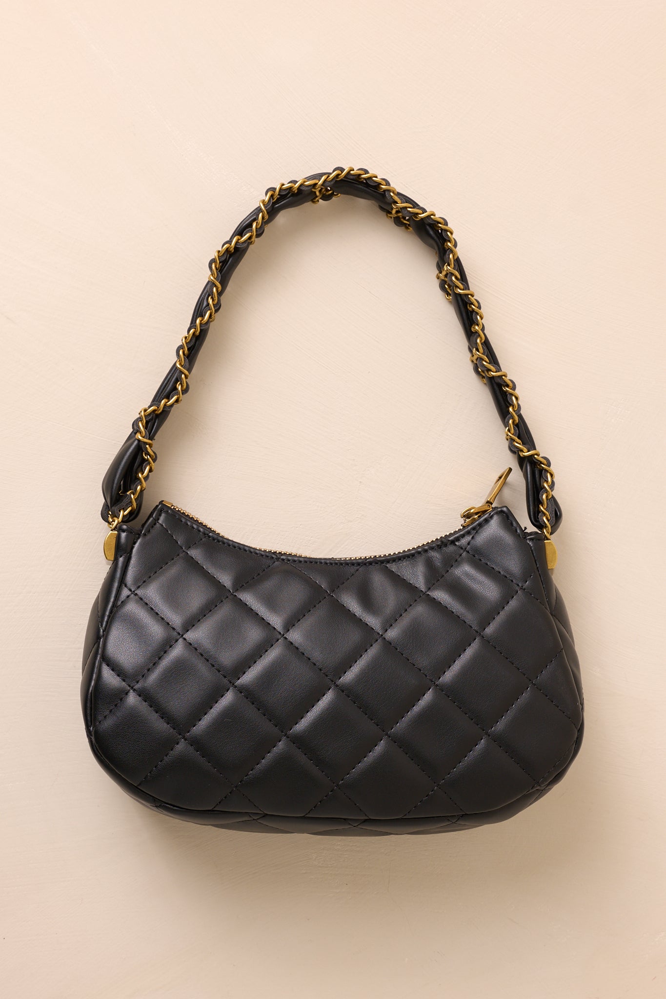 Quilted black handbag featuring a thick chain handle and structured rectangular shape.