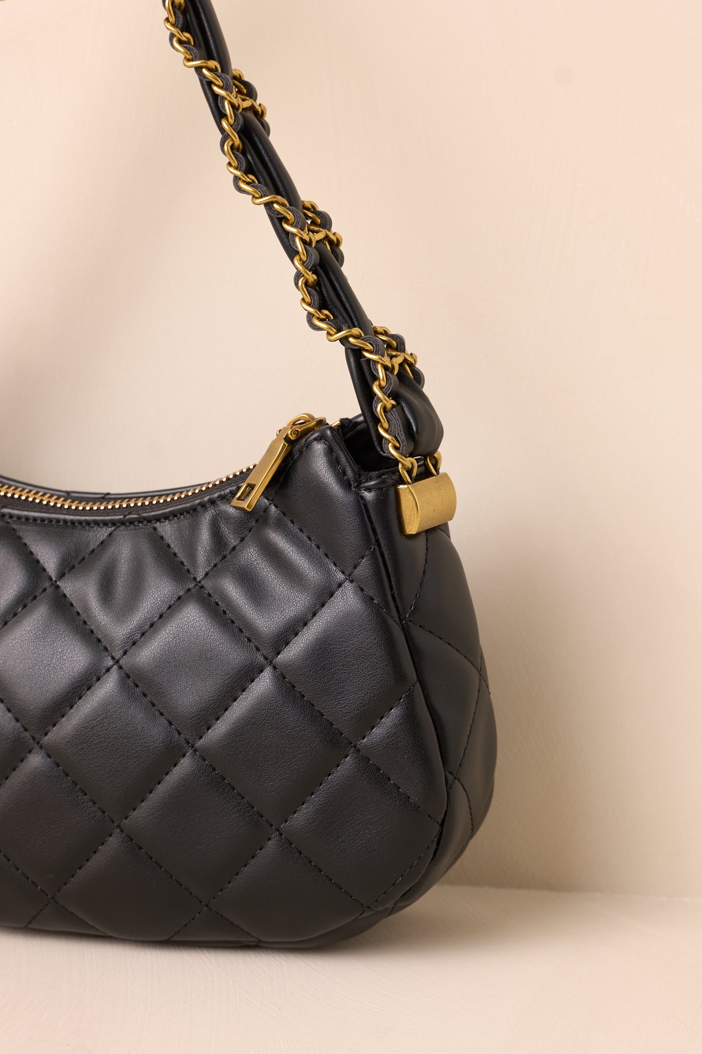 Close-up of the quilted pattern, gold hardware, and interior built-in zipper pocket and pouch.