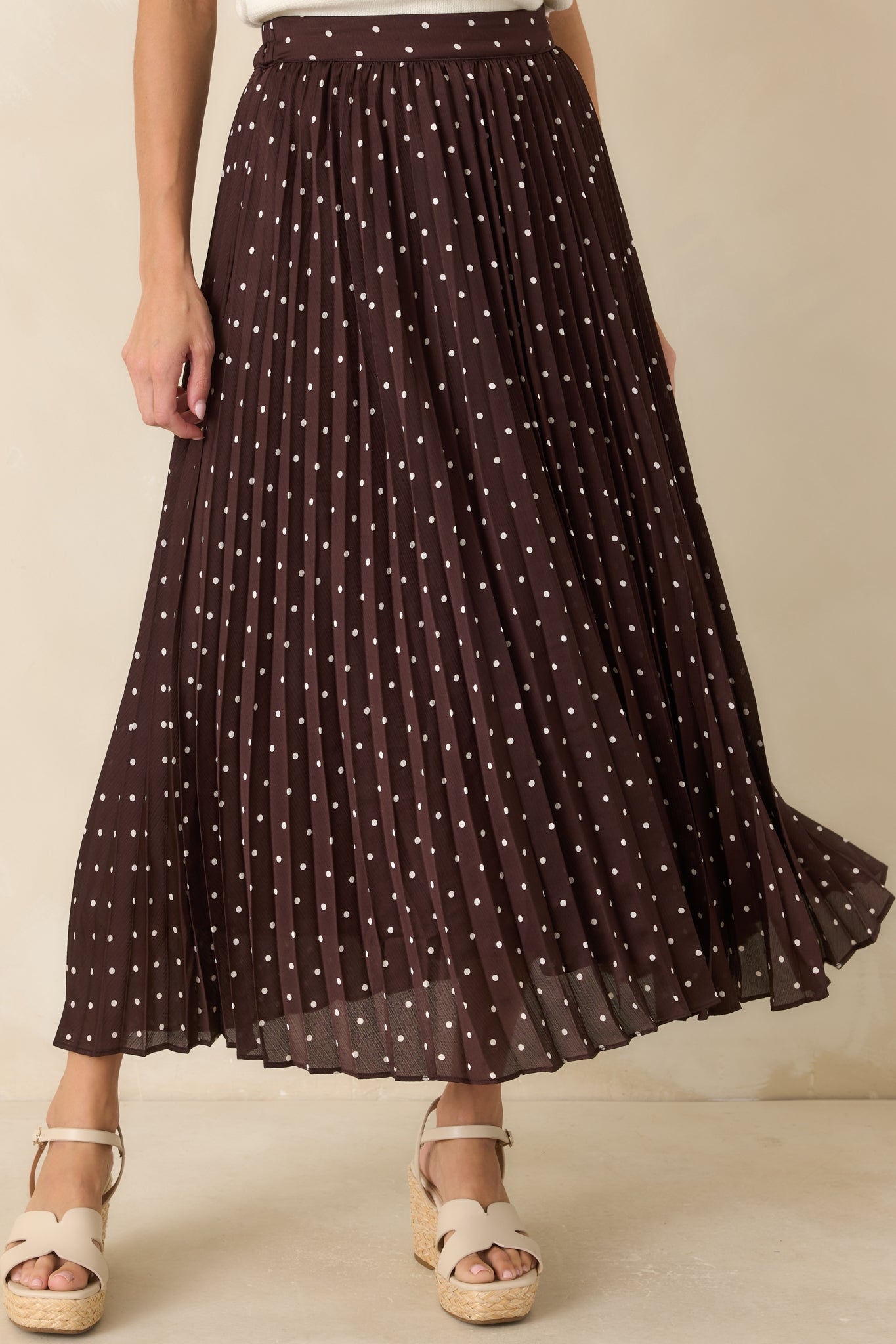 Detailed view of the accordion pleats highlighting the lightweight woven texture and dimensional finish of the skirt.