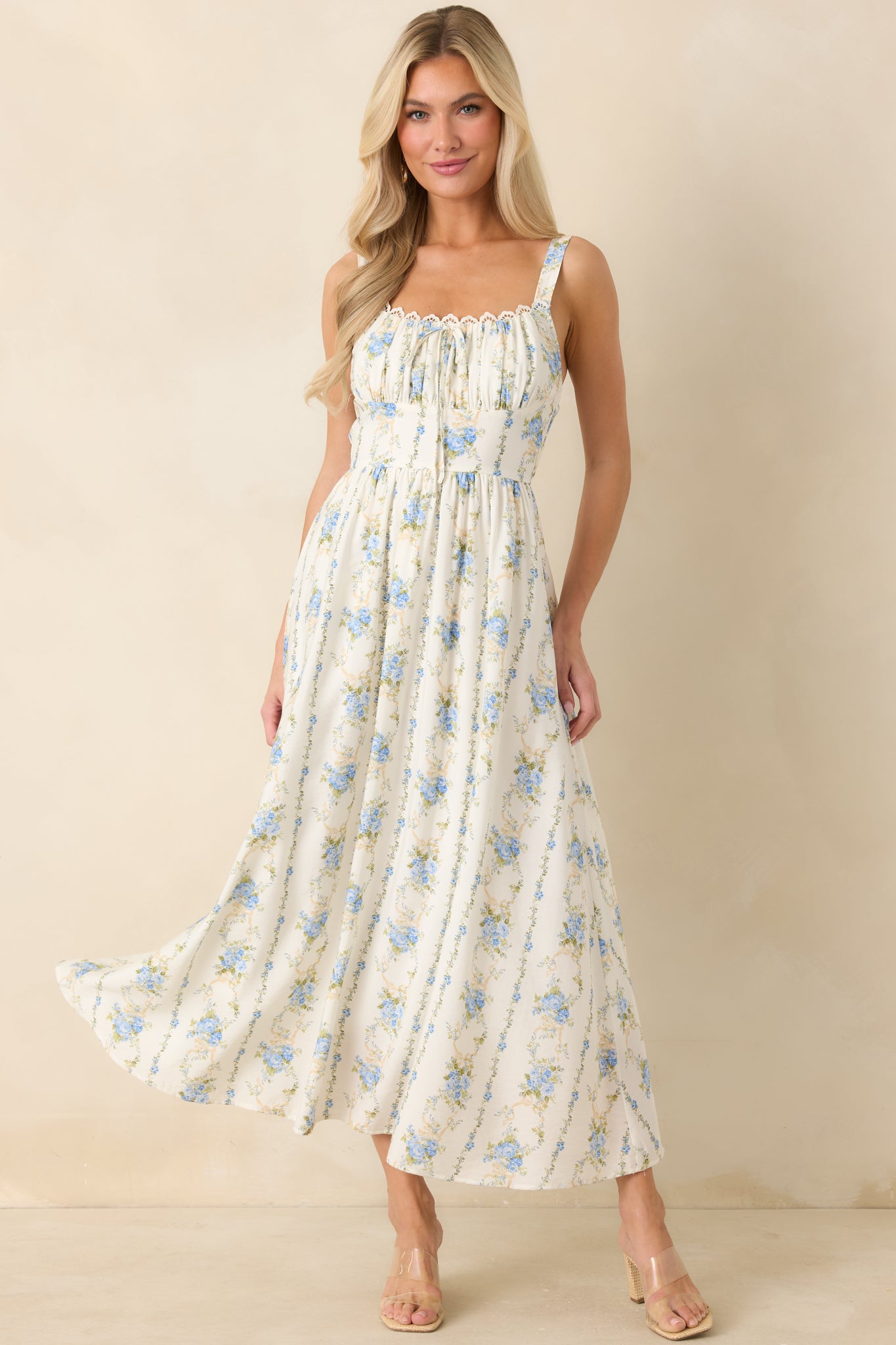Airy blue floral midi dress featuring adjustable straps, a softly gathered neckline, and a relaxed, flowing skirt.