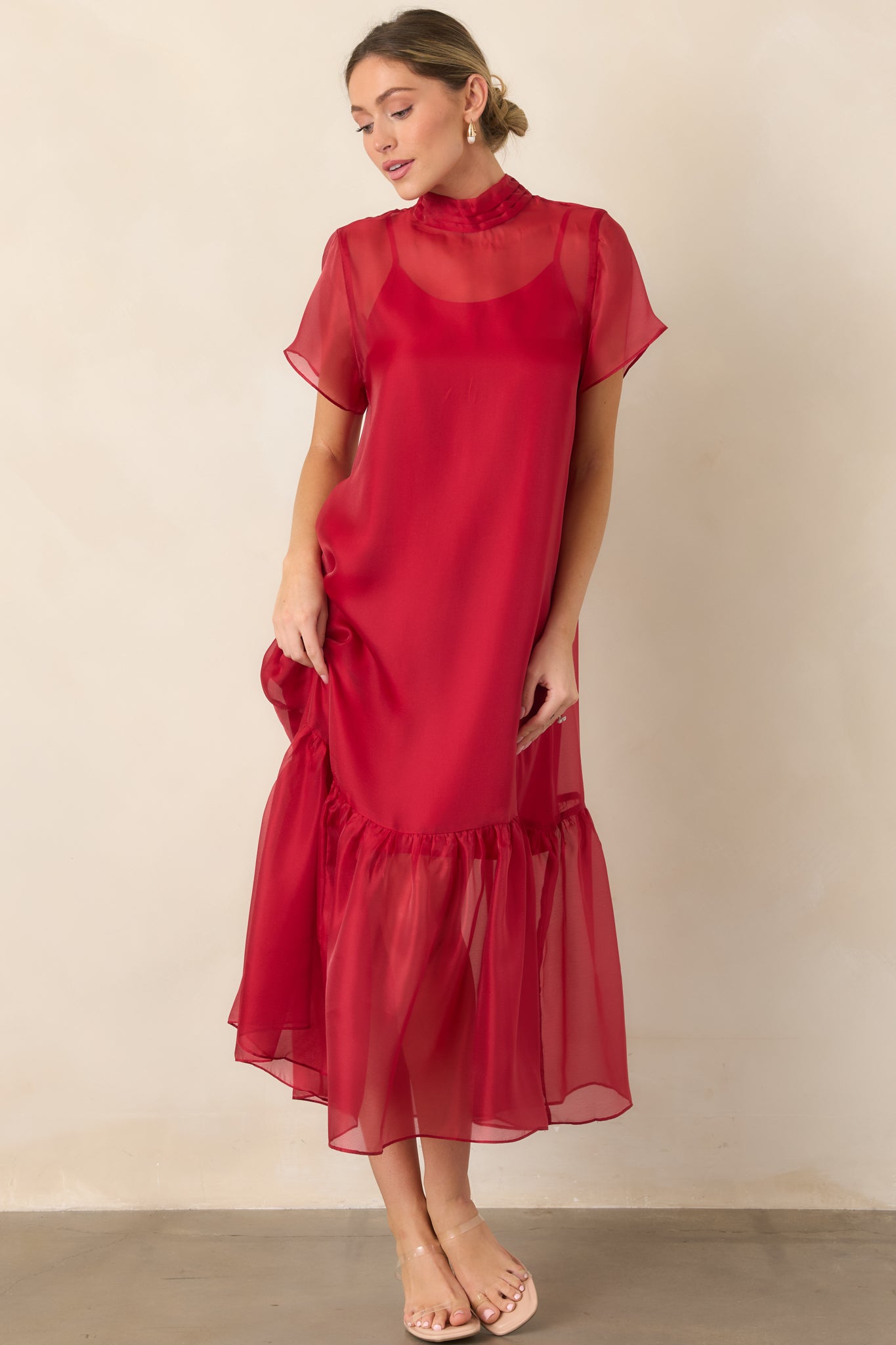Airy organza maxi dress showcasing a layered sheer overlay, high pleated neckline, short transparent sleeves, and flowing gathered hem.