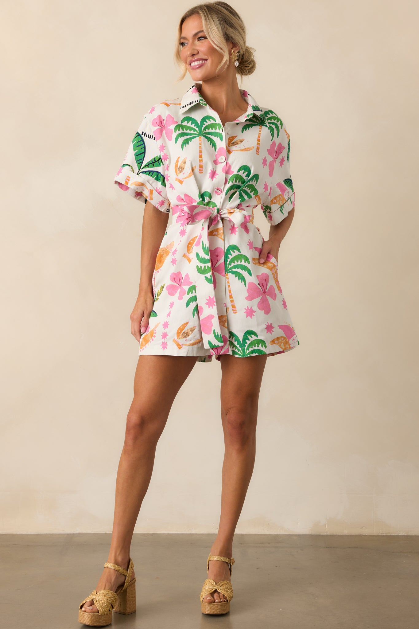 Three-quarter angle showing the romper’s relaxed fit, optional self-tie belt at the waist, and visible front pockets.