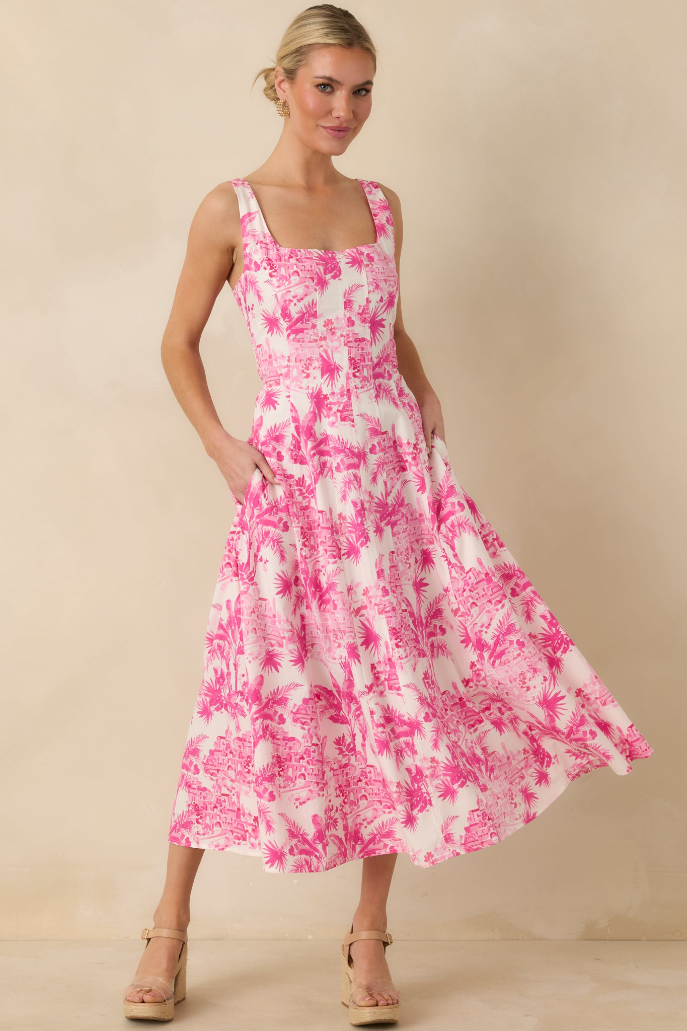 Angled front perspective highlighting the allover palm print and smooth fabric drape of the hibiscus pink dress.