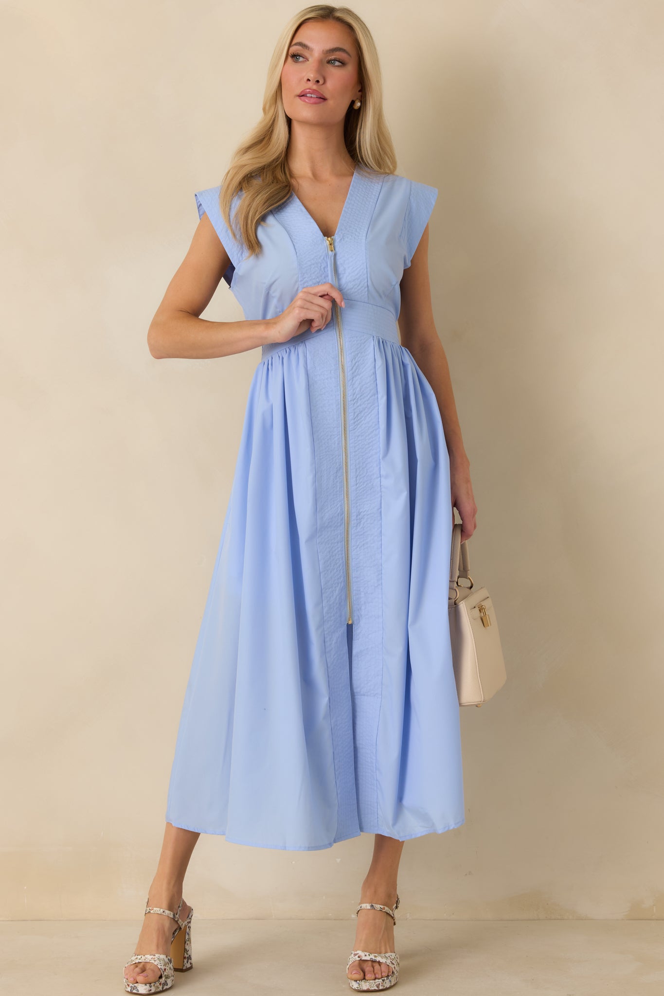 Angled front perspective highlighting the lightly gathered skirt and smooth drape of the light blue midi dress.