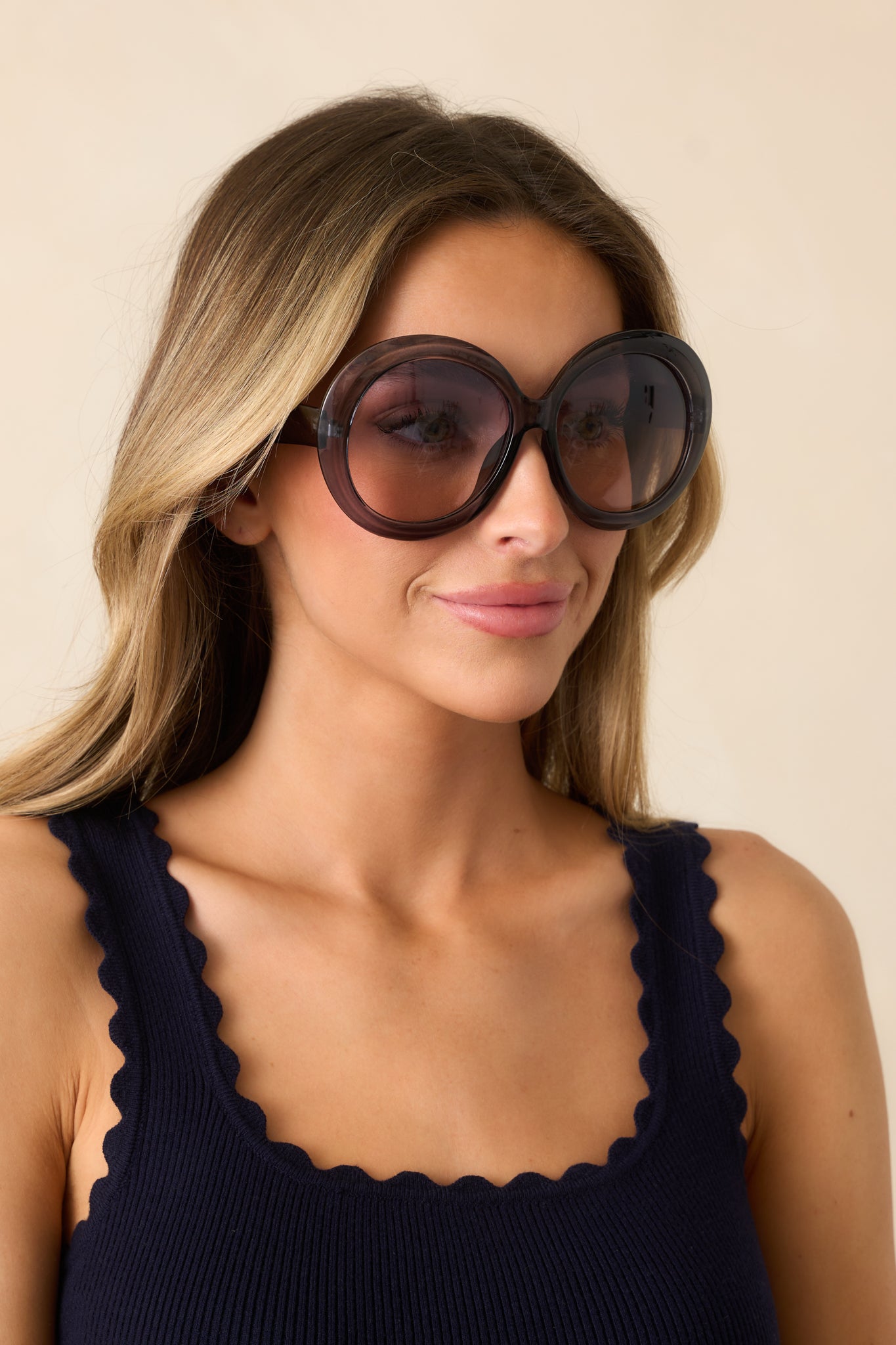 An angled shot of the black sunglasses highlighting the large, rounded frames, and sheer black ombre lenses with a secure nose piece.