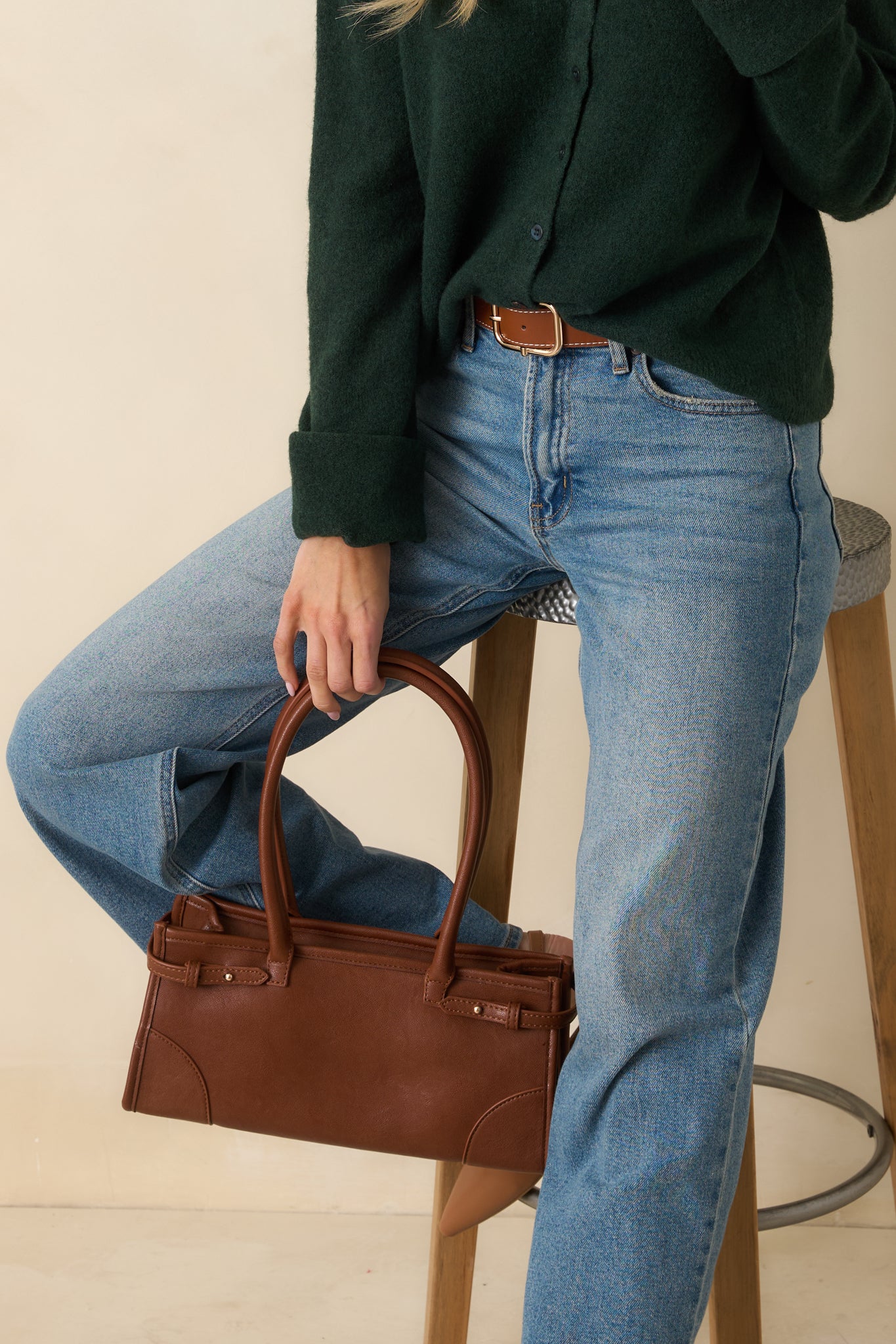 Angled front view highlighting the structured design, top zip closure, and gold hardware of the cognac handbag.