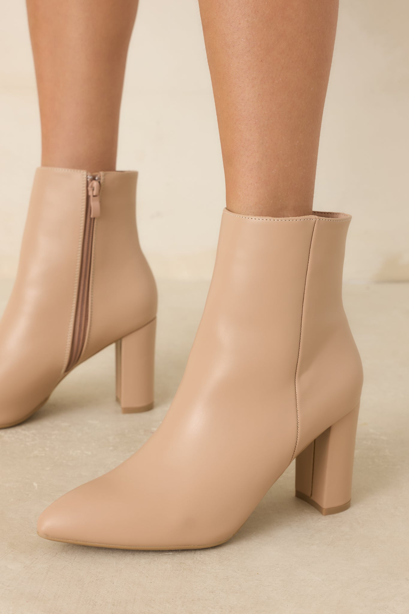 Angled view of the ankle boots showcasing the sleek silhouette and functional inner zipper closure.