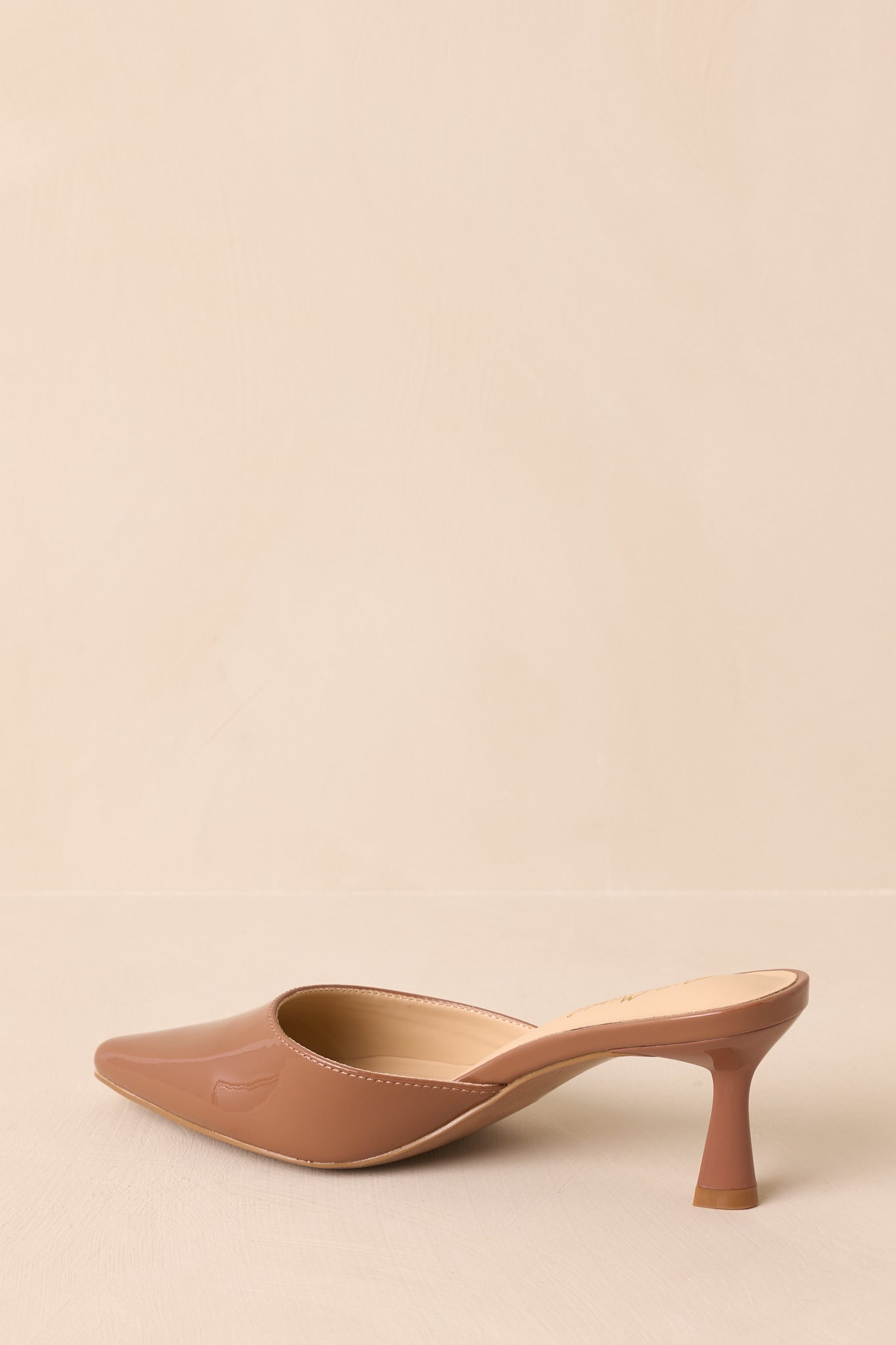 Angled view of mocha brown mule highlighting glossy material and kitten heel shape.