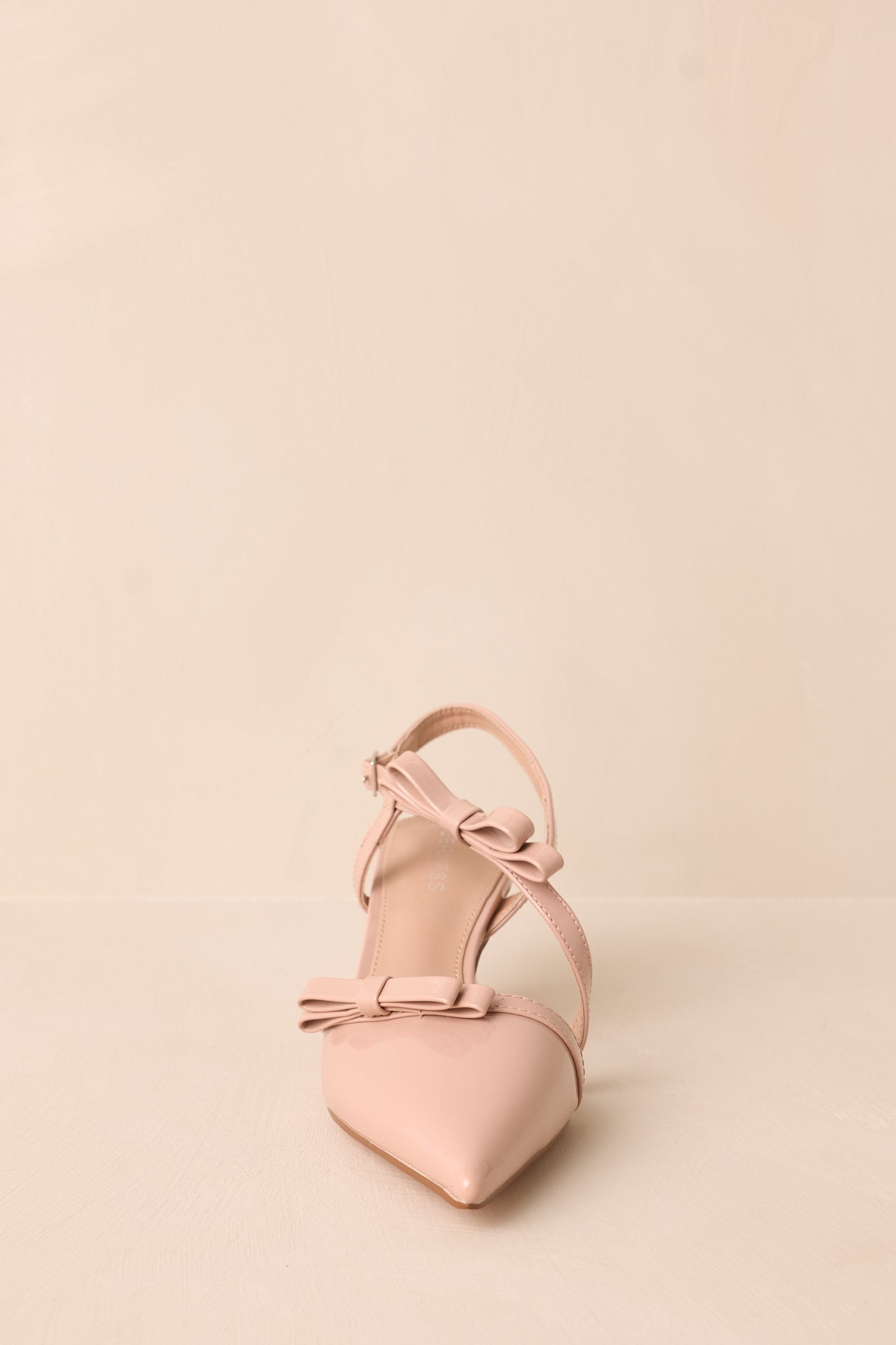 Dynamic shot capturing the pointed toe, strap details, and the moderate height of the kitten heel.