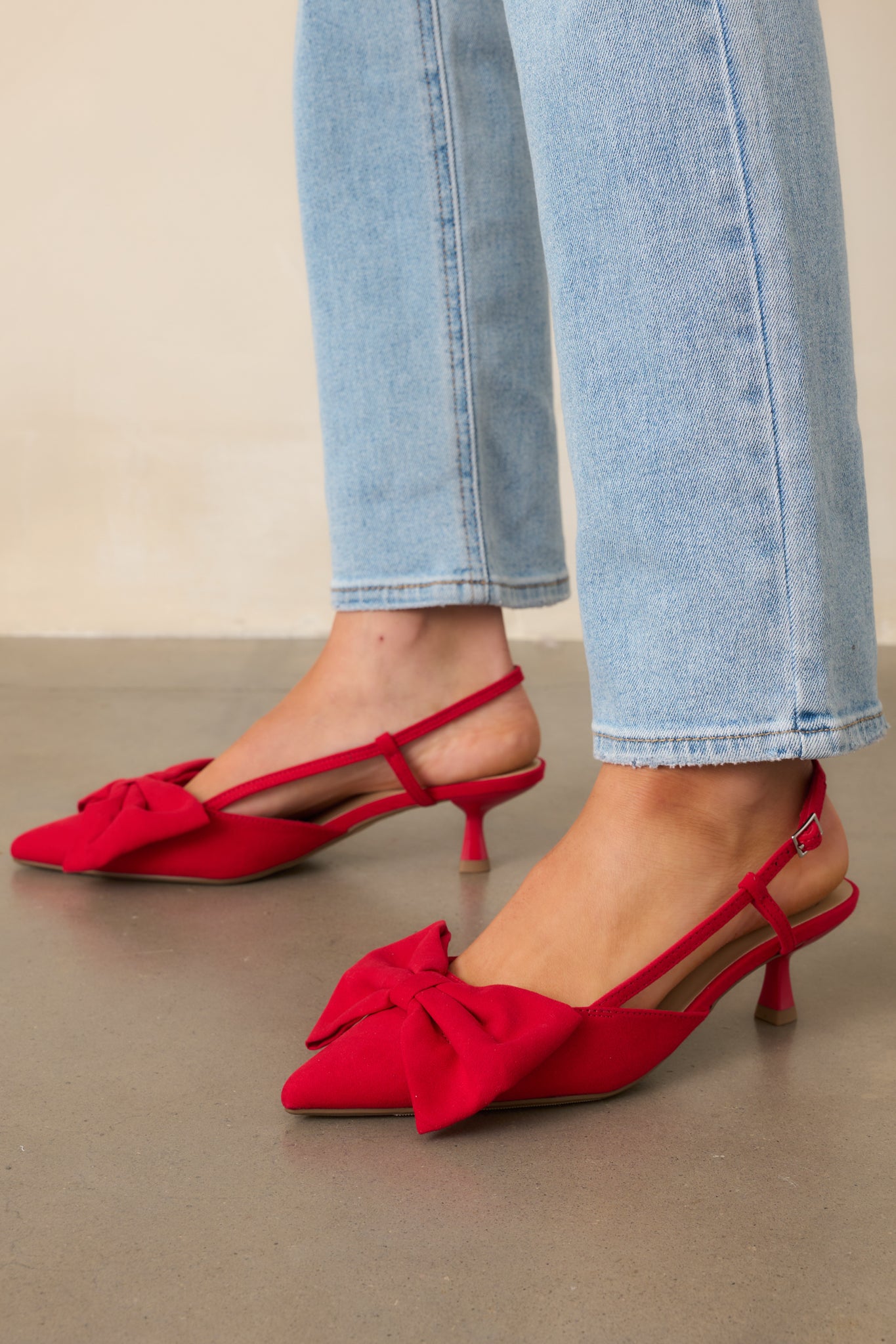 Angled view of the red heels showing the bow accent and smooth material.