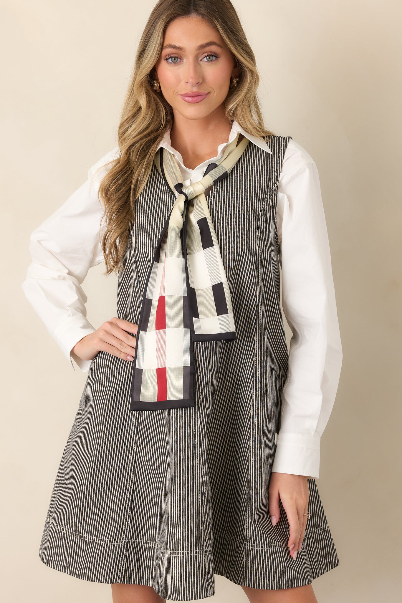 Close view of the anthracite grey dress highlighting its deep V-neckline, fine ivory stripes, and sleeveless construction.