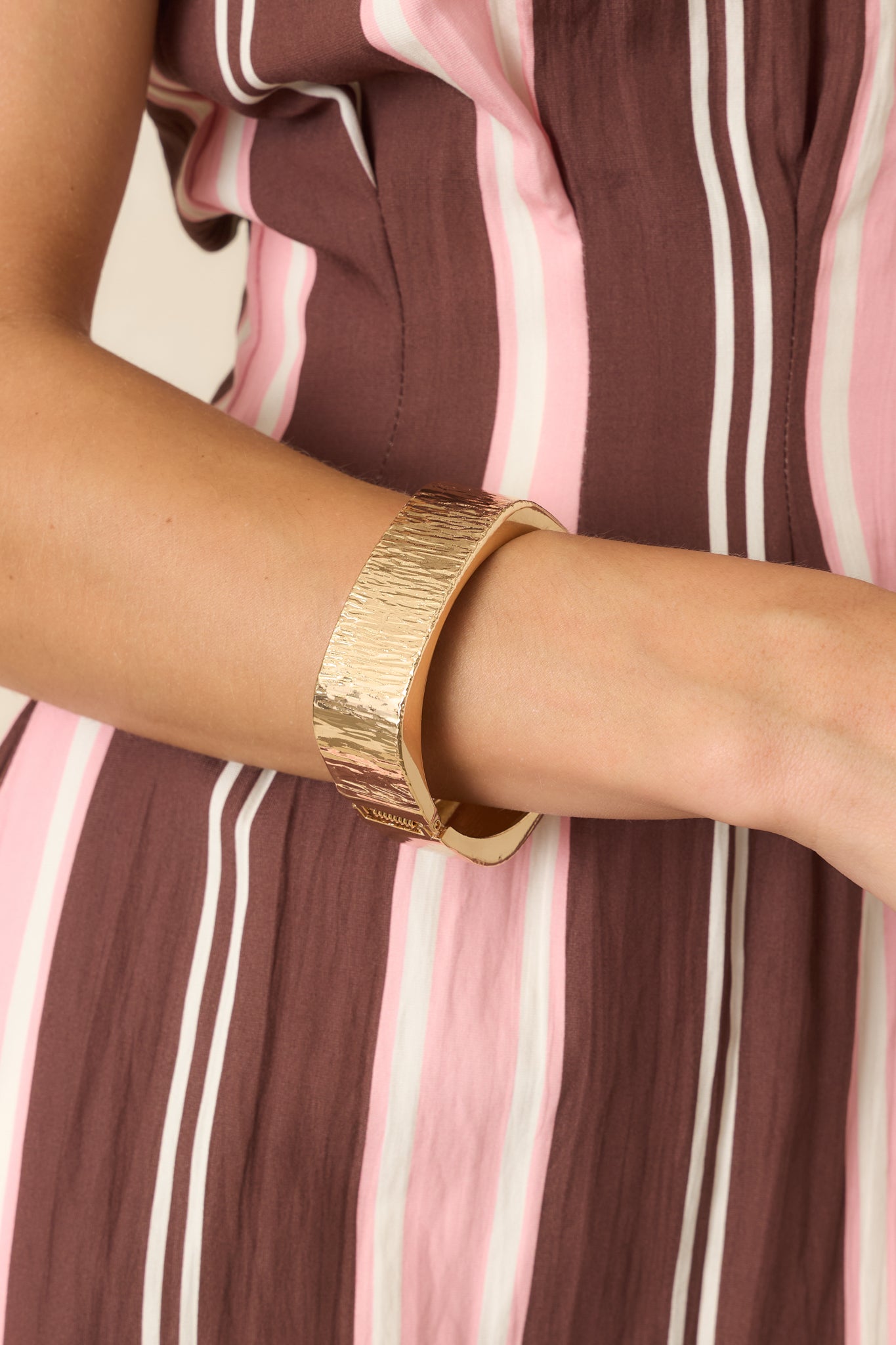 Architectural gold cuff showcasing clean lines, wide profile, brushed texture, and sophisticated statement design.
