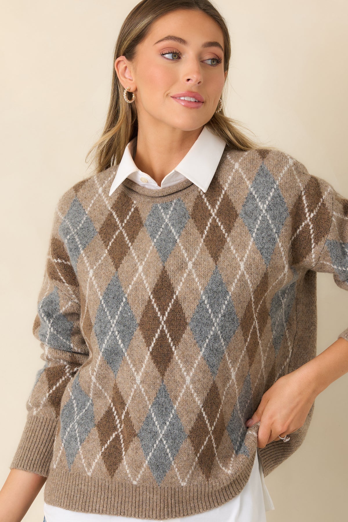 Rolled-edge round neckline frames the cream and taupe textured knit pattern of the sweater.