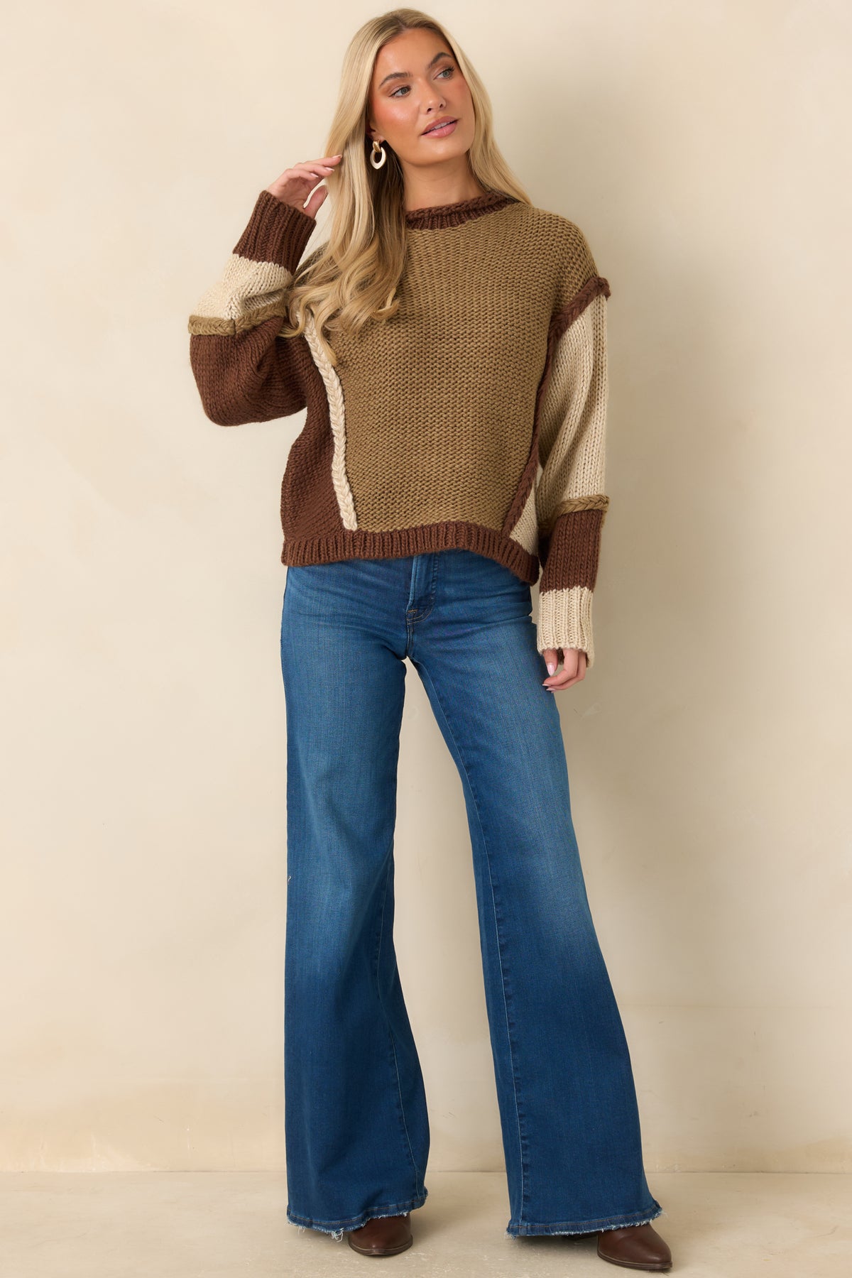 Relaxed sweater featuring asymmetrical color placement, dropped shoulders, and long sleeves with mixed knit patterns.