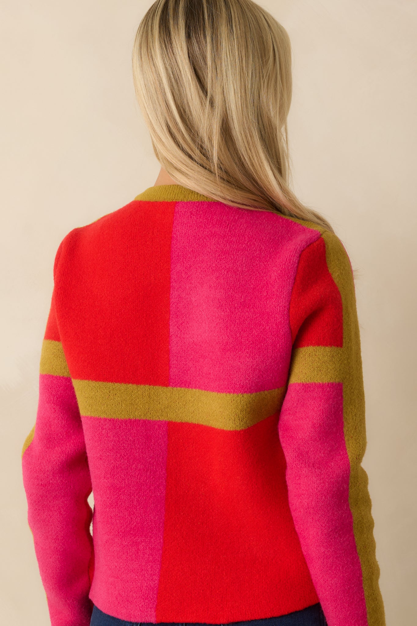 The back of the cardigan shows the full color block pattern with smooth knit fabric and a relaxed fit.