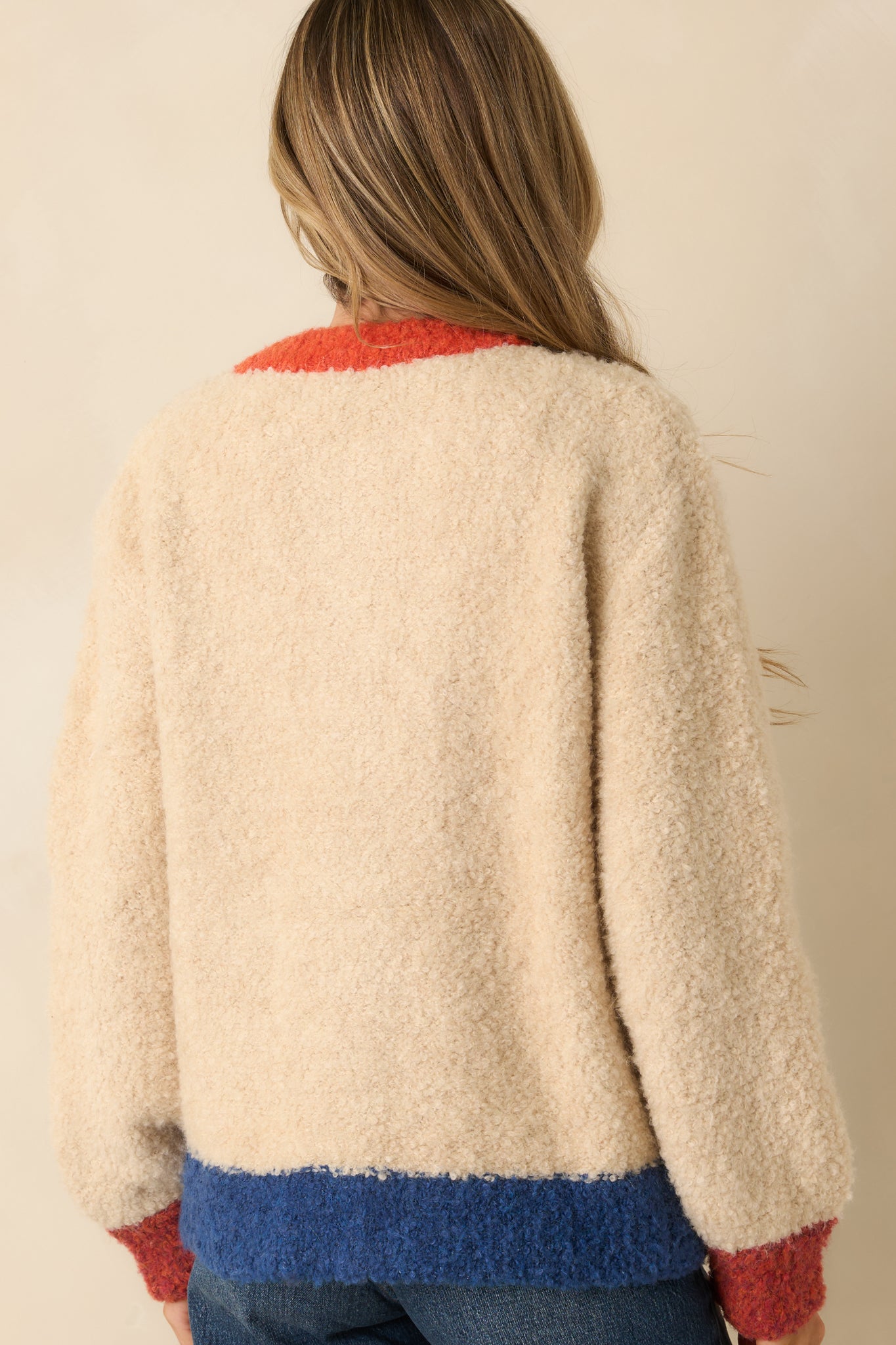 The back of the cardigan shows the smooth boucle knit with multicolor block design and long sleeves in relaxed silhouette.