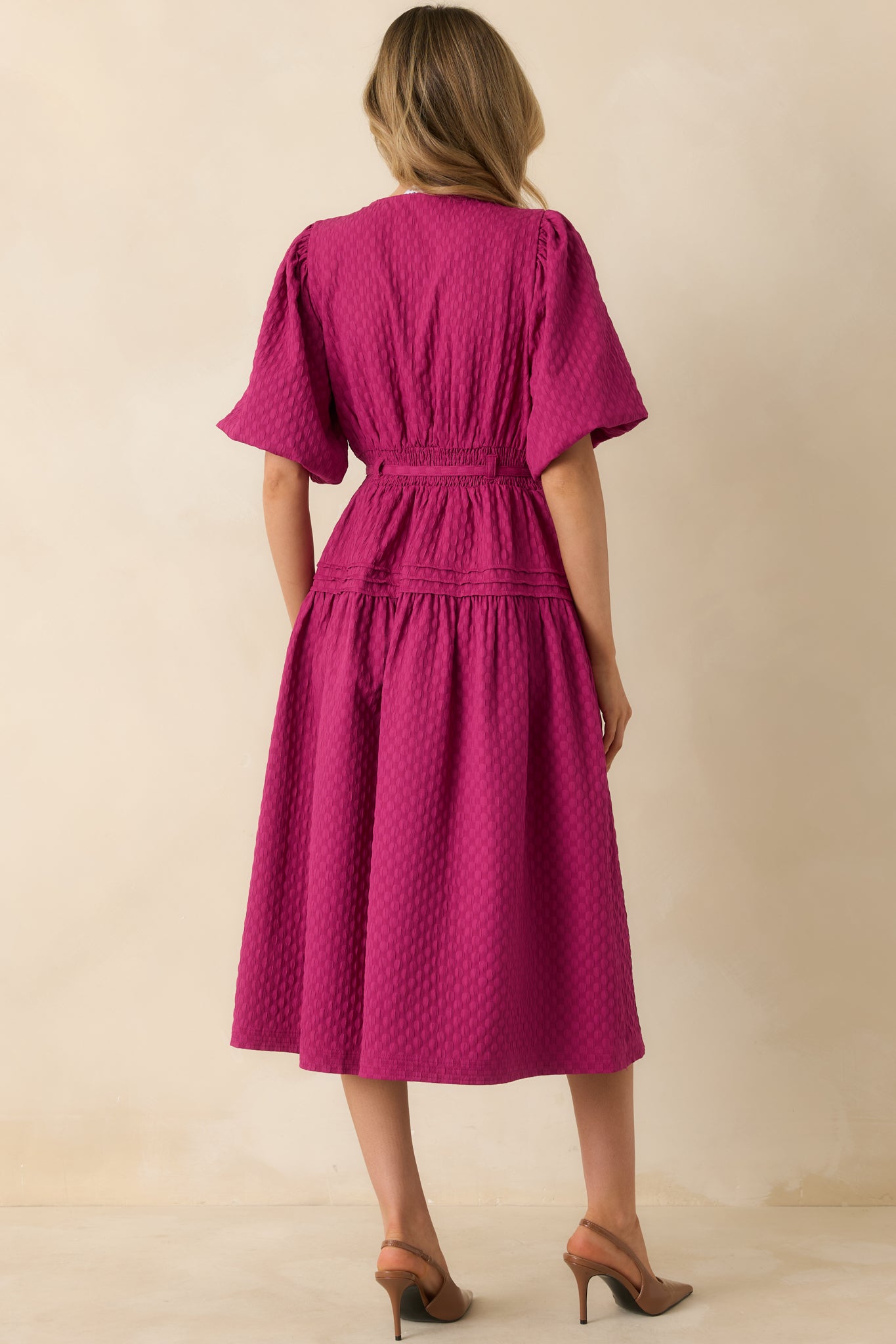 The back of the dress shows the smooth woven fabric, flowing midi skirt, and the tie waist creating subtle shaping.