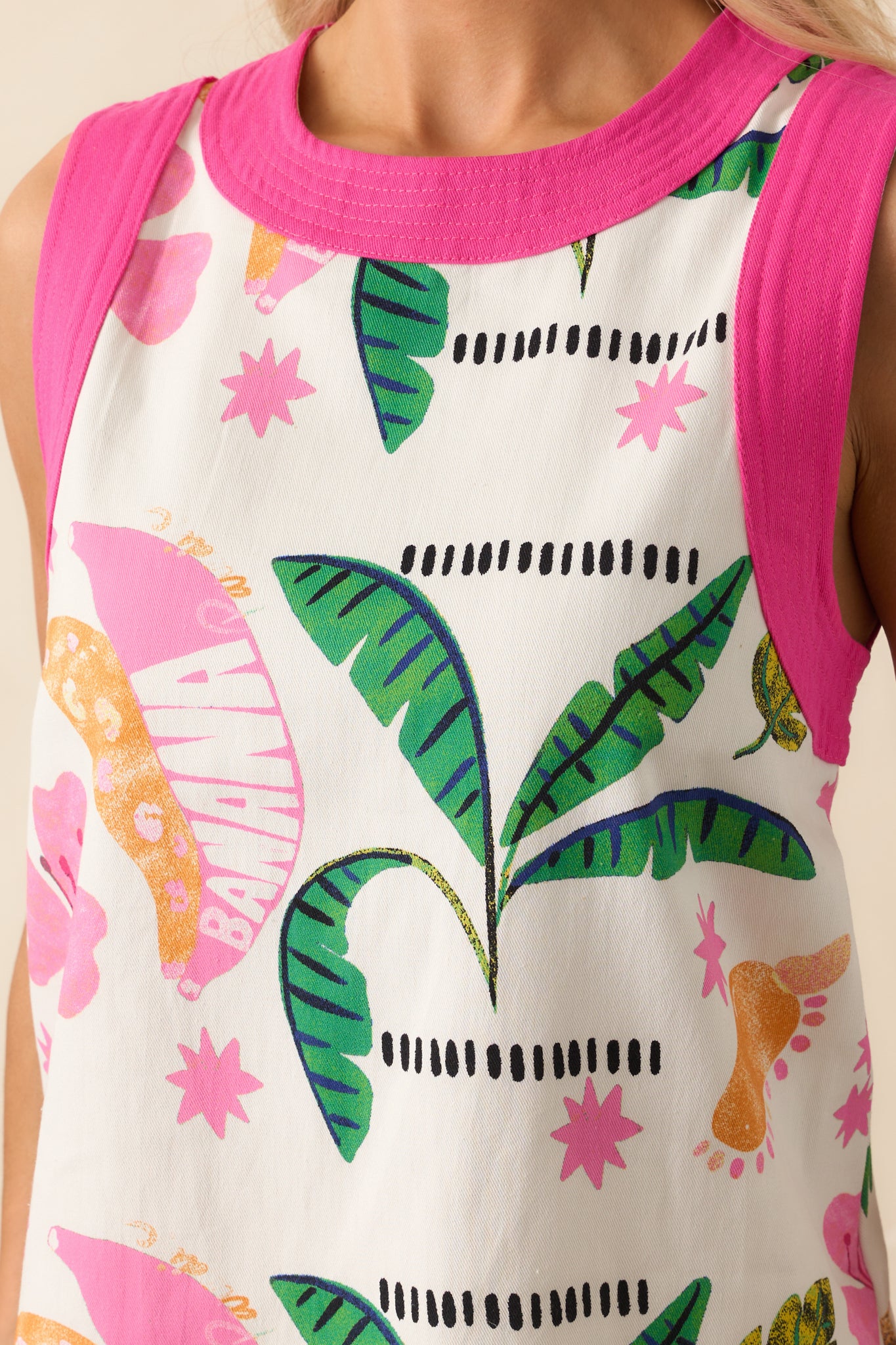 Detailed image of the back keyhole button closure framed by pink trim and surrounded by the multicolor tropical print.
