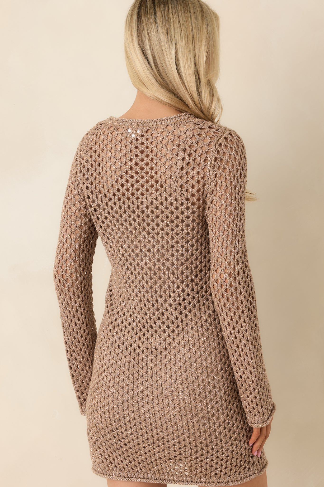 Back view of mocha crochet mini dress featuring semi-sheer open-knit fabric, long sleeves, and ribbed trim at cuffs and hem.