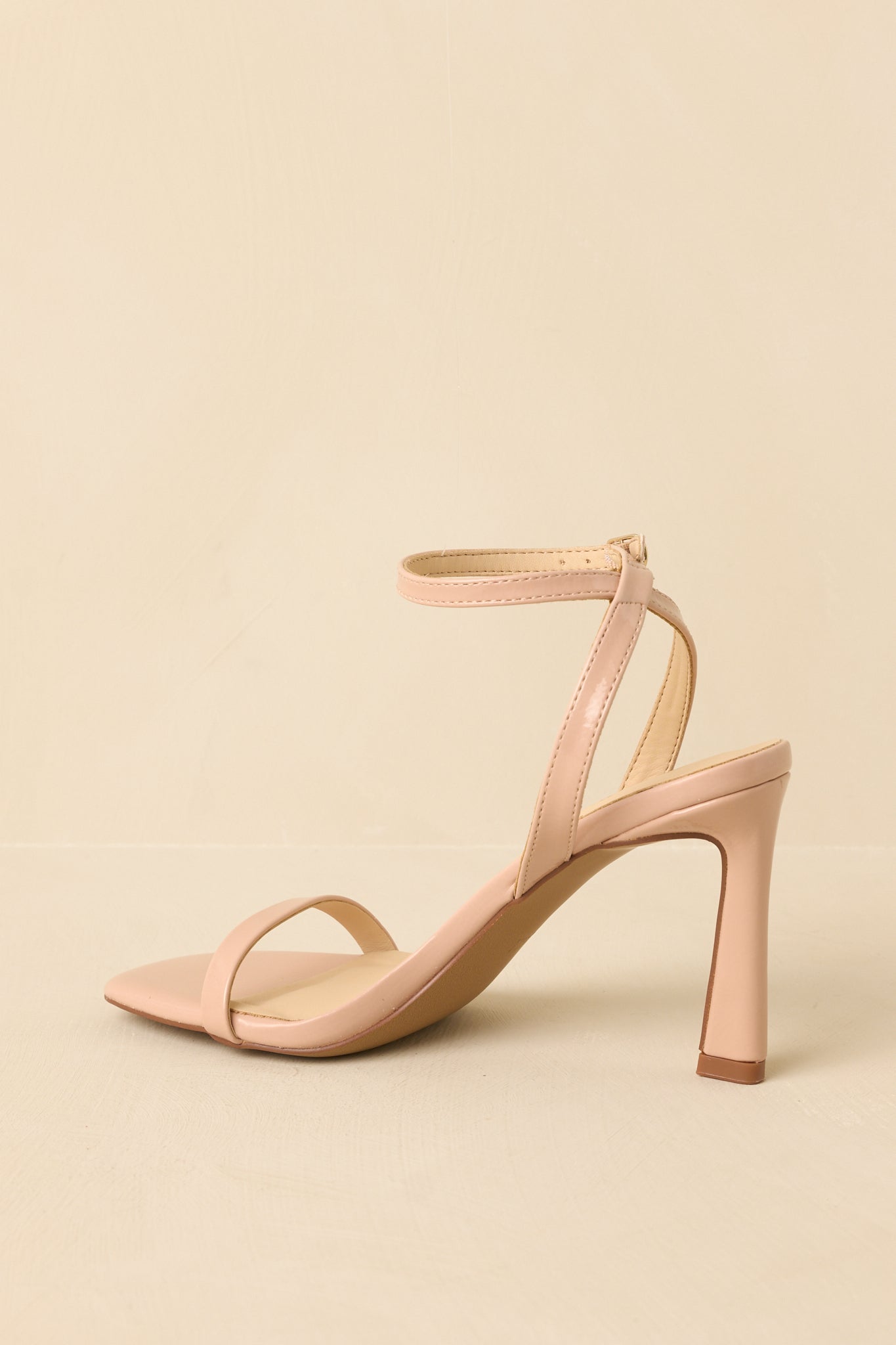 Back view of the nude heels highlighting the adjustable ankle strap and secure buckle closure.