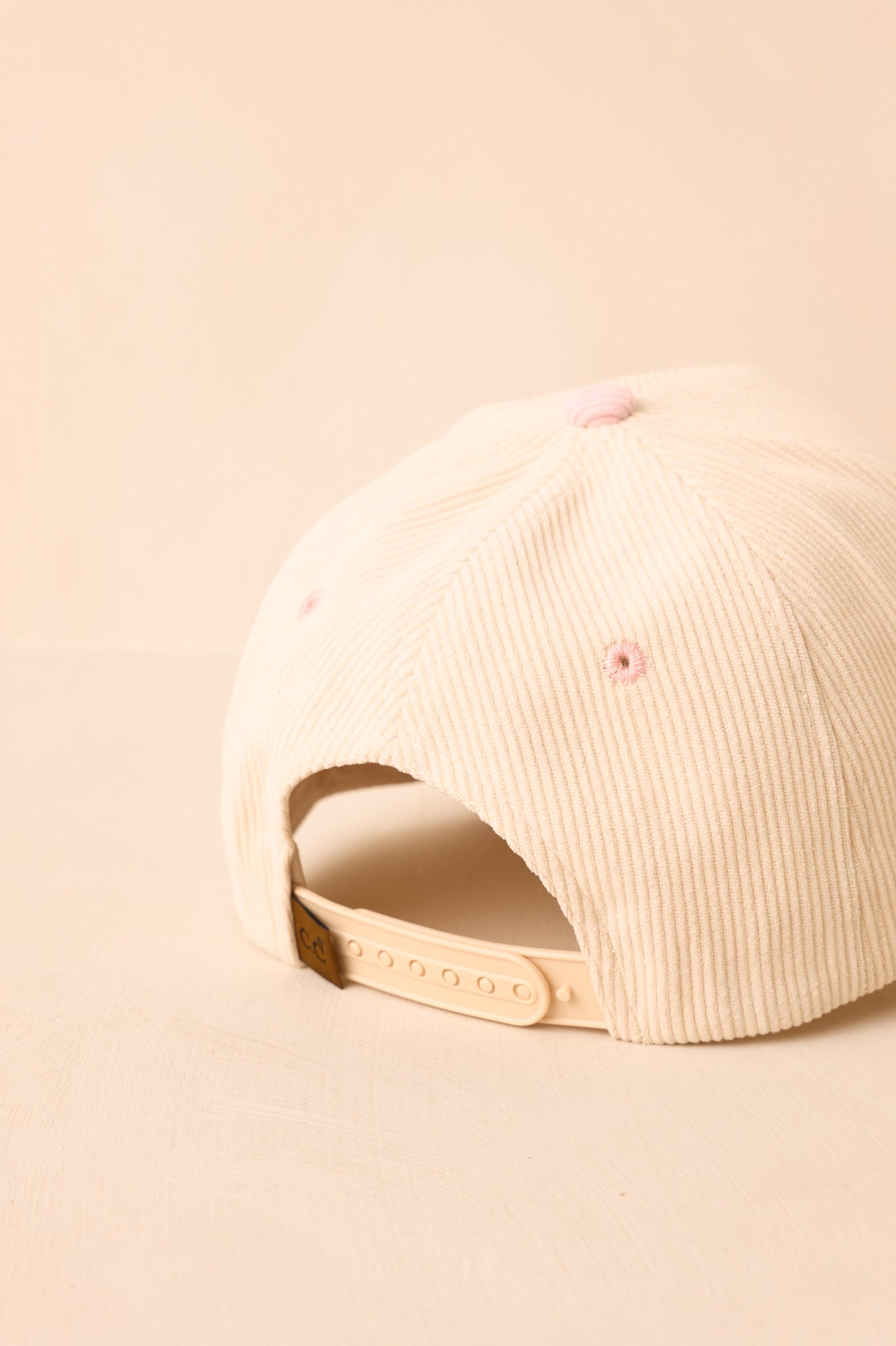 Back of a beige cap on a beige background.
