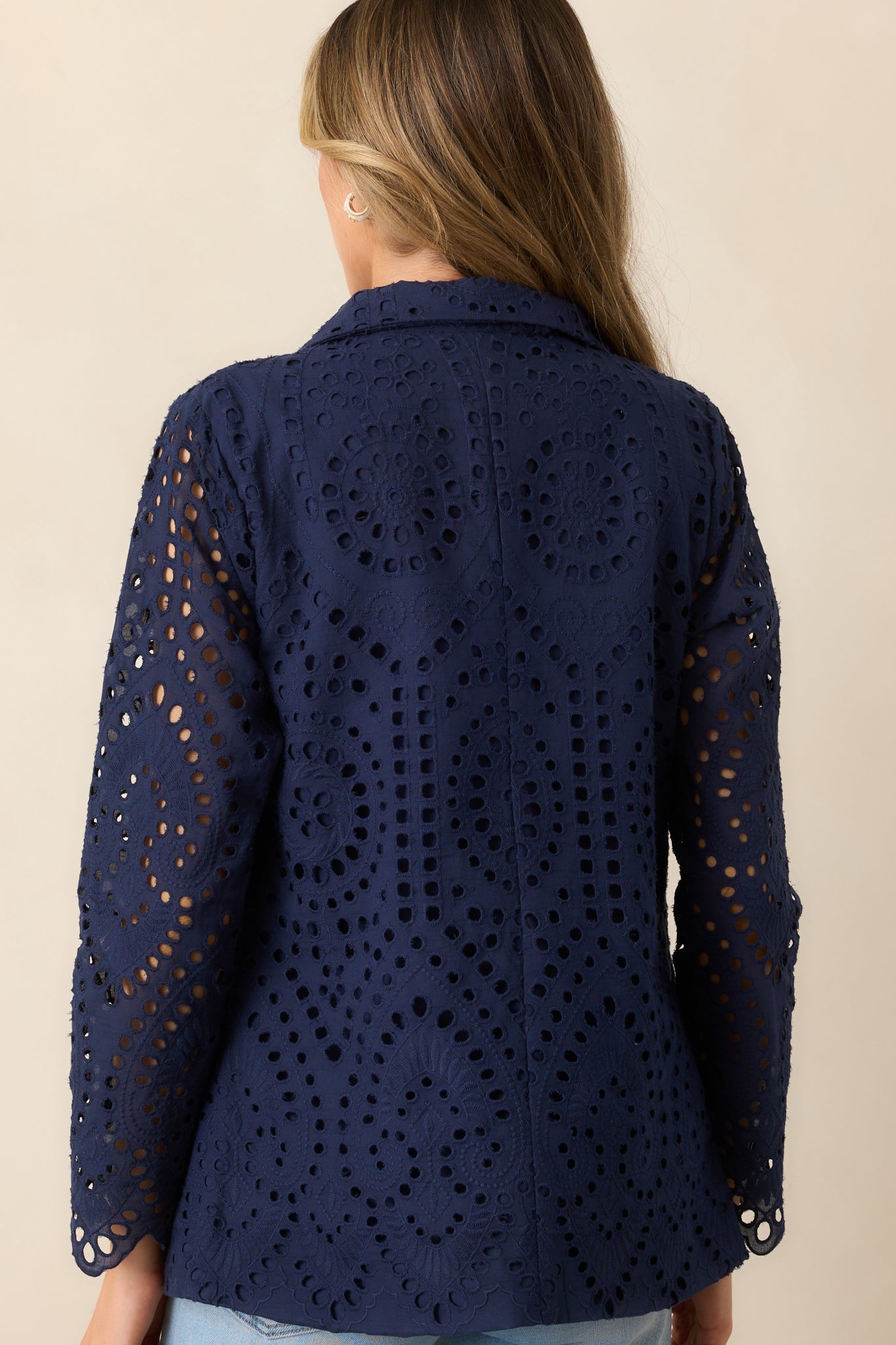 The back of this navy blazer highlights its structured fit and elegant eyelet embroidery, blending classic and modern design.