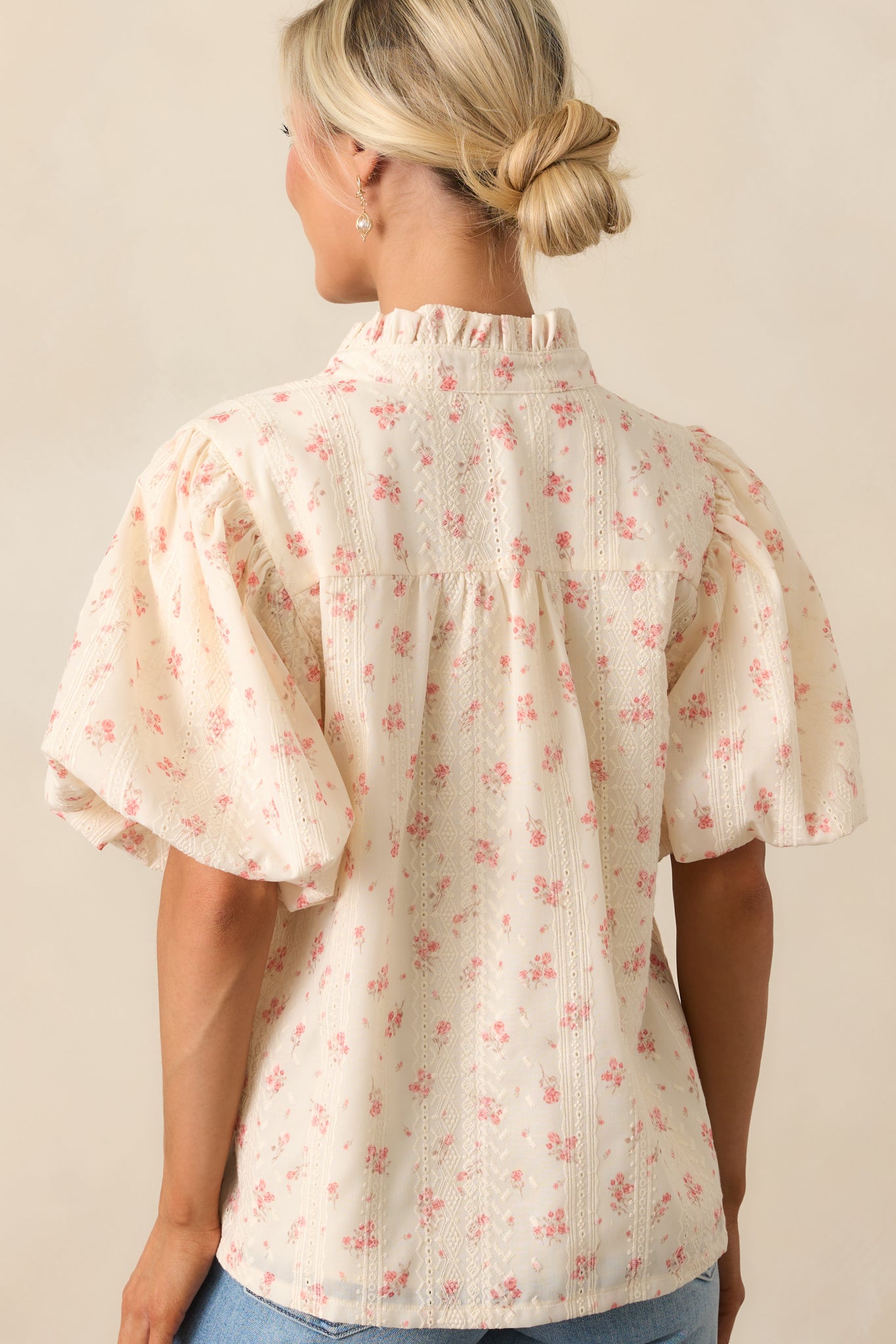The back of the blouse showcases the textured fabric and puff sleeves, creating a beautifully structured silhouette.