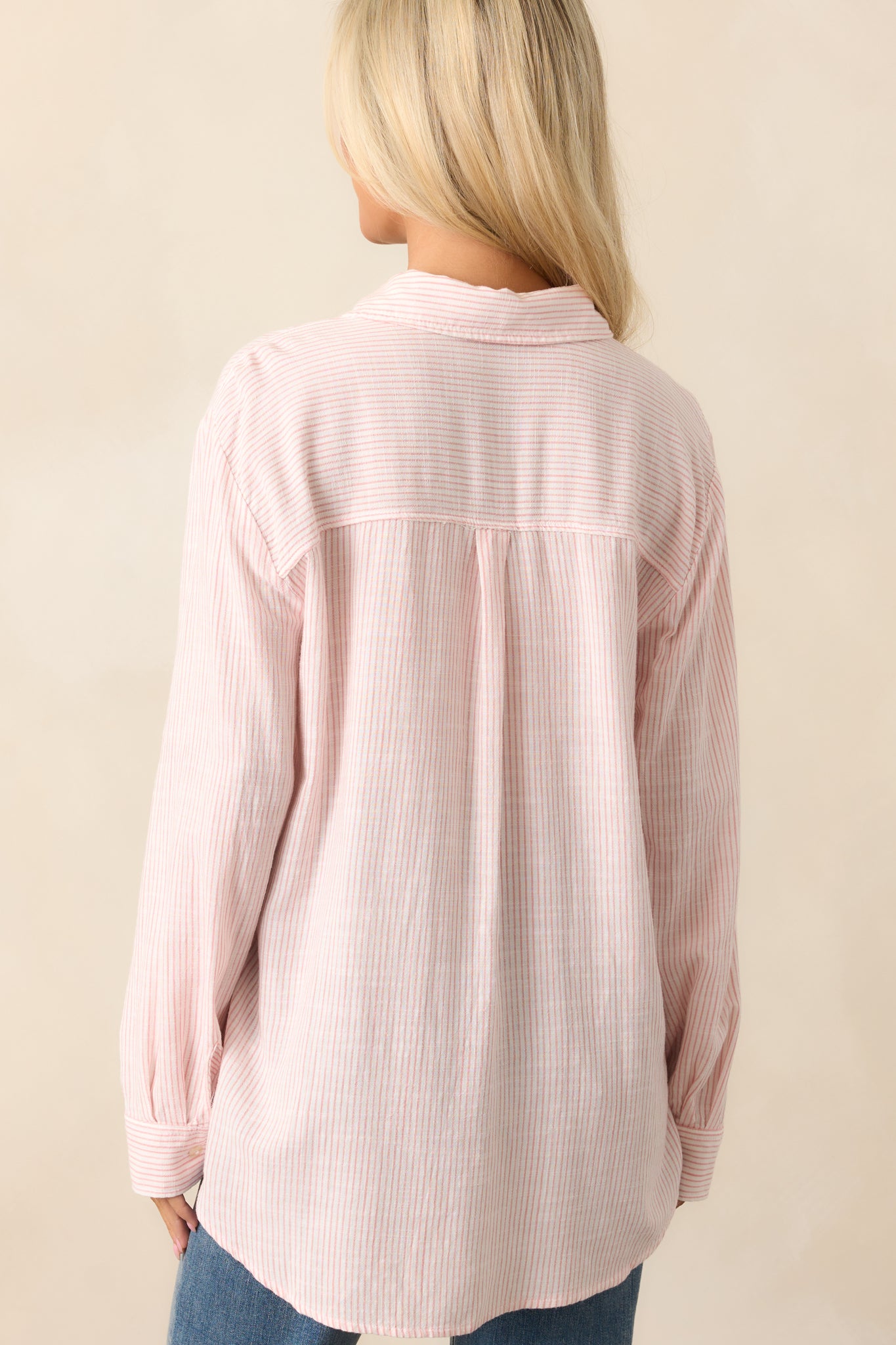 The back of the pink striped top, displaying the flowing fit and collar detail from behind.