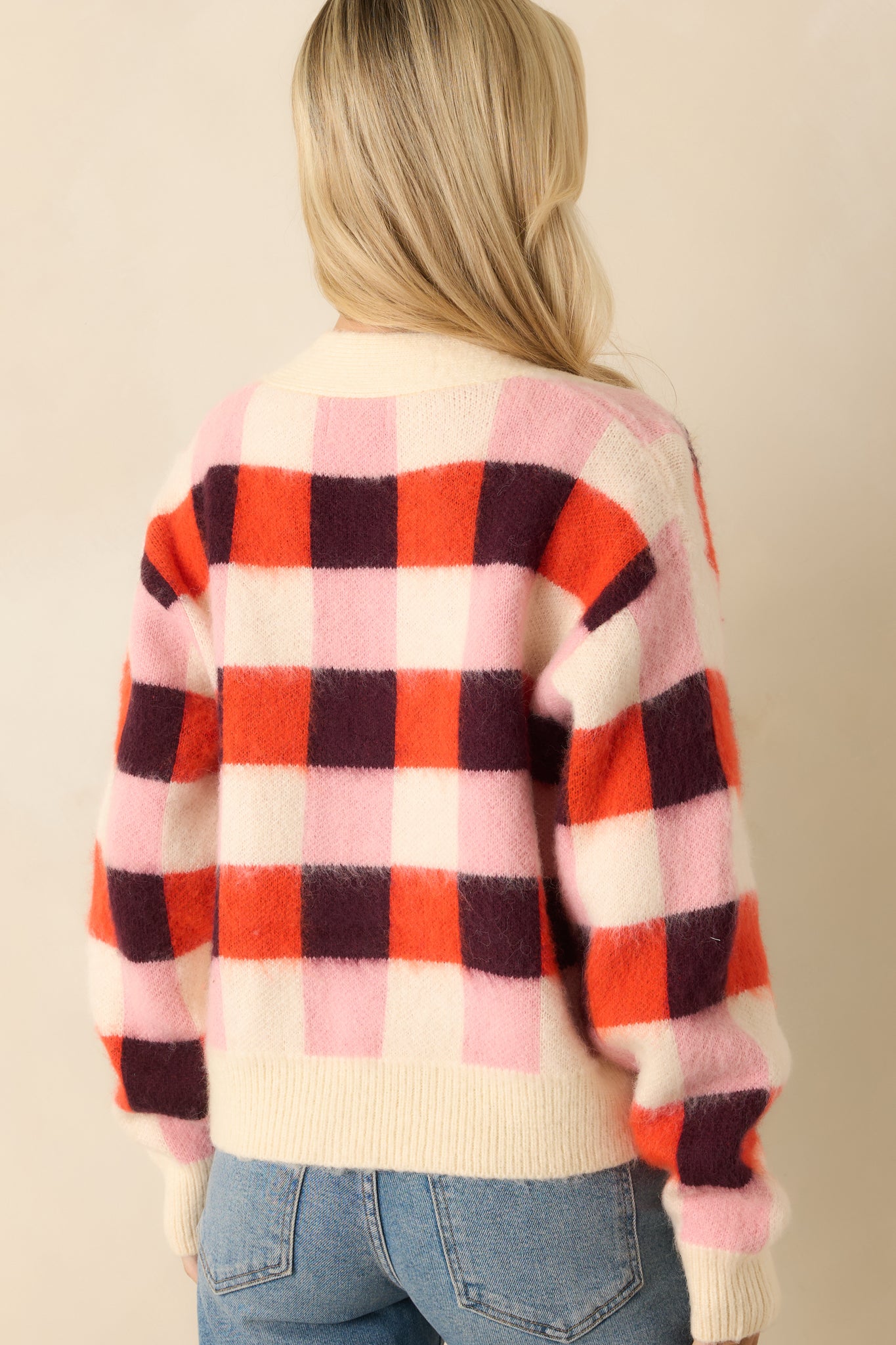 The back of the cardigan displays the soft fuzzy knit with multicolor checks and long sleeves in a relaxed silhouette.