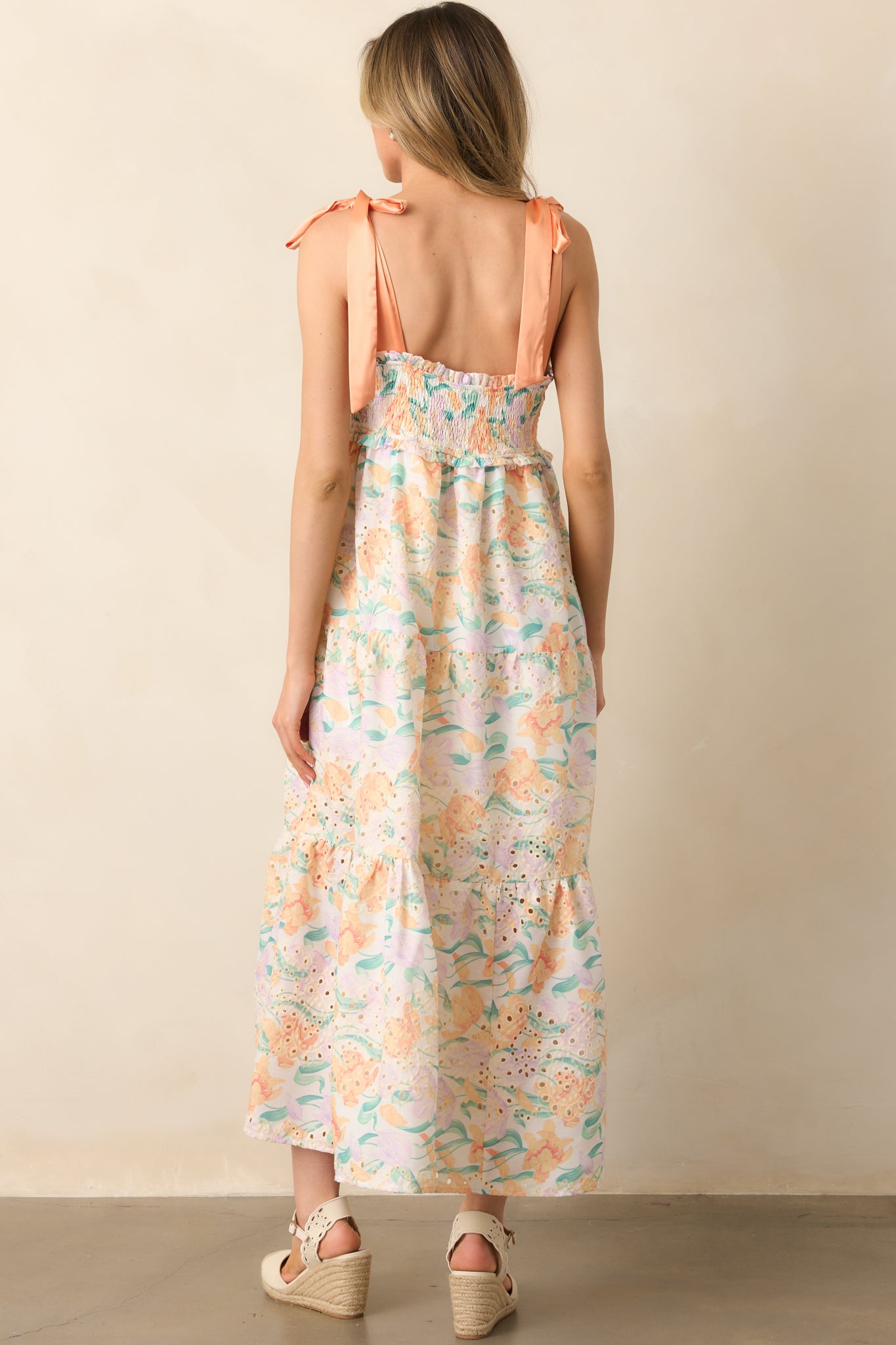 The back of the dress highlights the adjustable satin bow straps and smocked bust, ensuring a comfortable and secure fit with a delicate, feminine touch