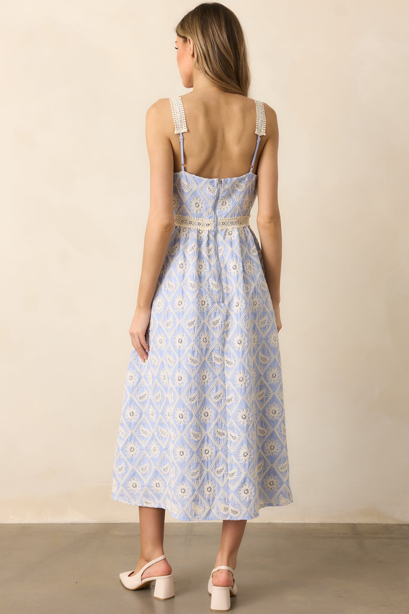 The back of the periwinkle dress, showcasing the adjustable straps and the overall elegant, feminine design that complements the lace embroidery and v-neckline.