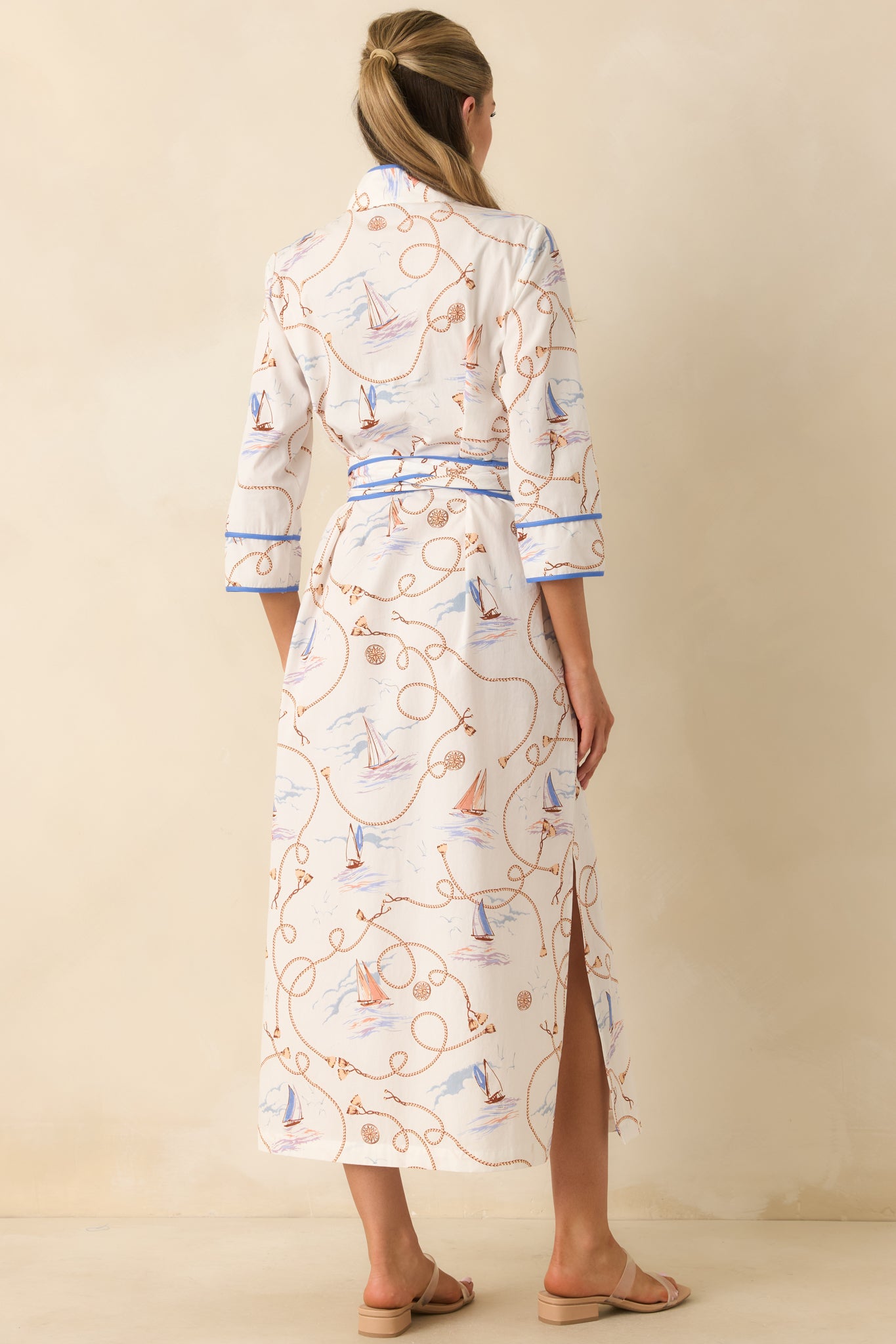 Back view of the cotton maxi dress featuring three-quarter sleeves, a cinched sash waist, and flowing silhouette.