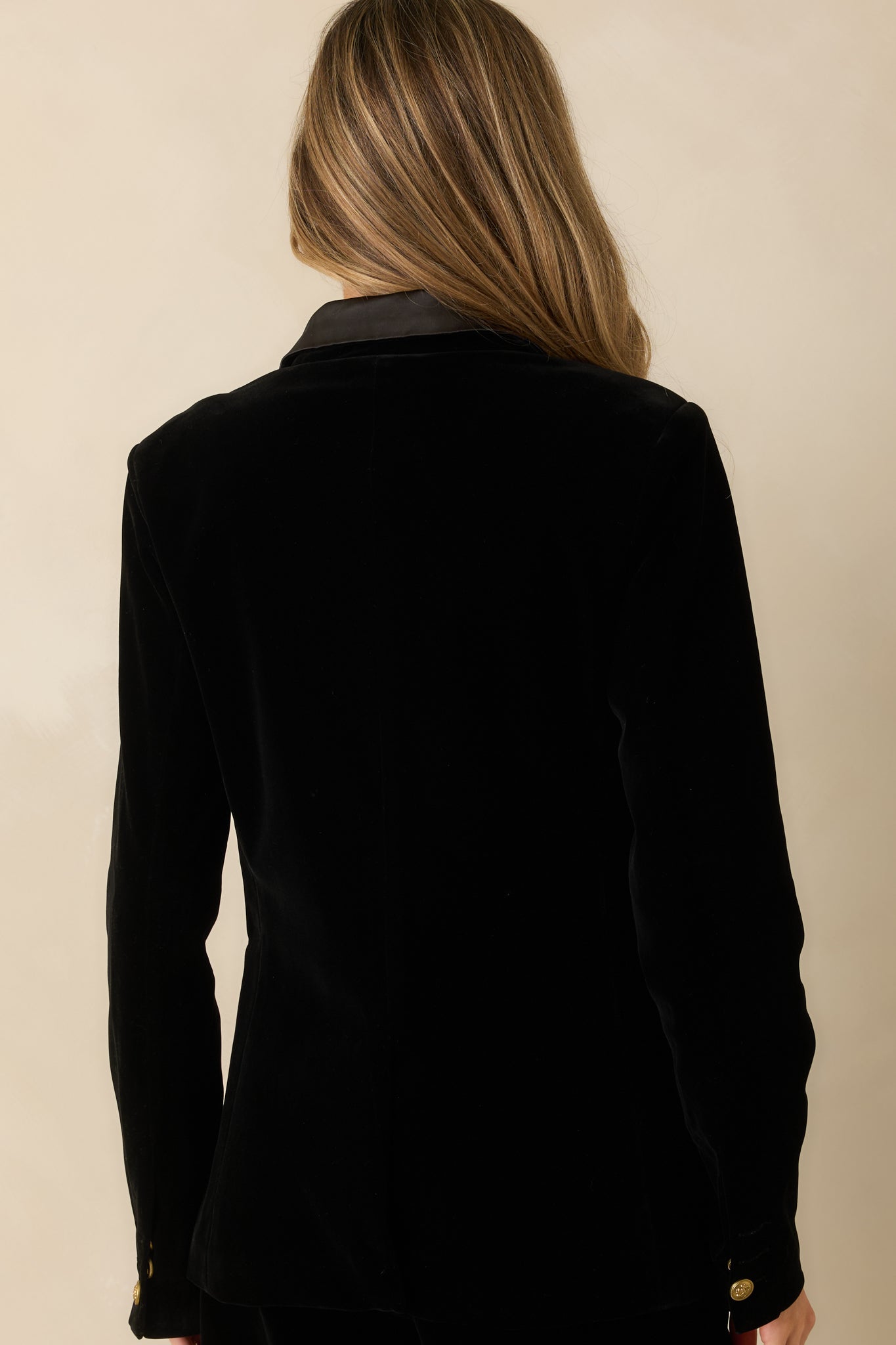Back view showing the fully lined back, structured shoulders, and long sleeves of the black blazer.