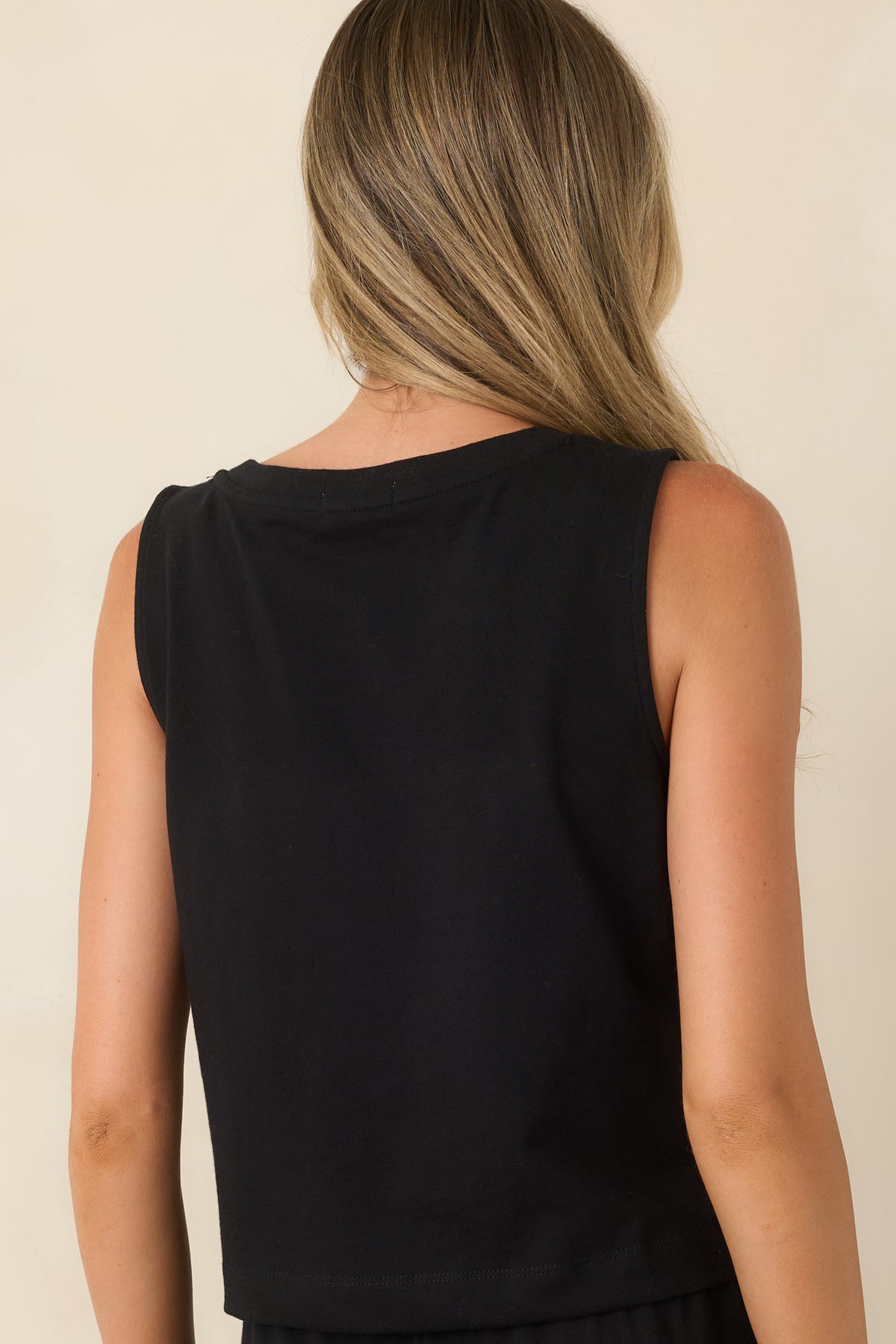 Back view of the black cotton tank highlighting the relaxed fit and cropped length.