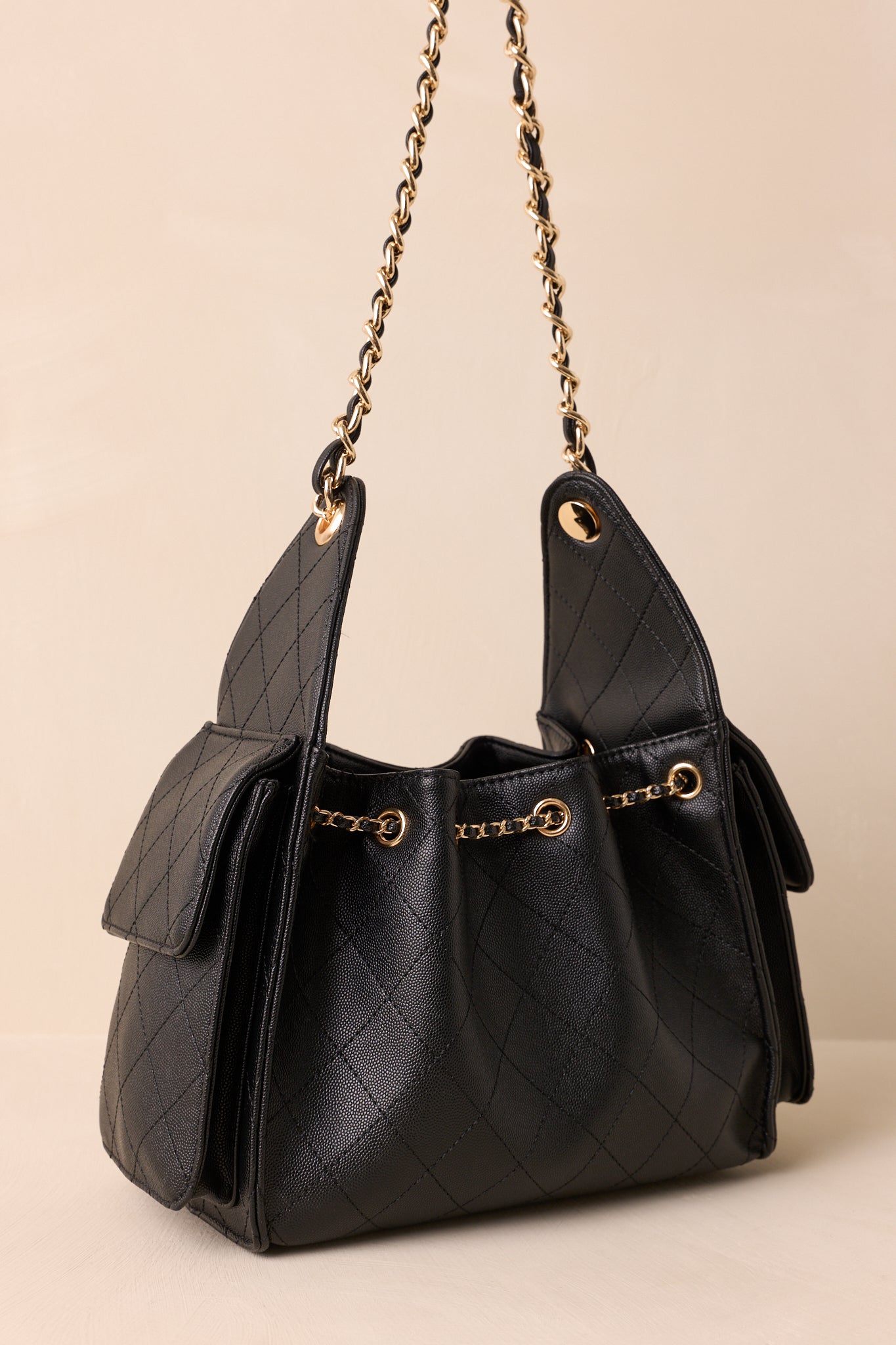 Back view of the black quilted purse showing the smooth back panel and structured silhouette.