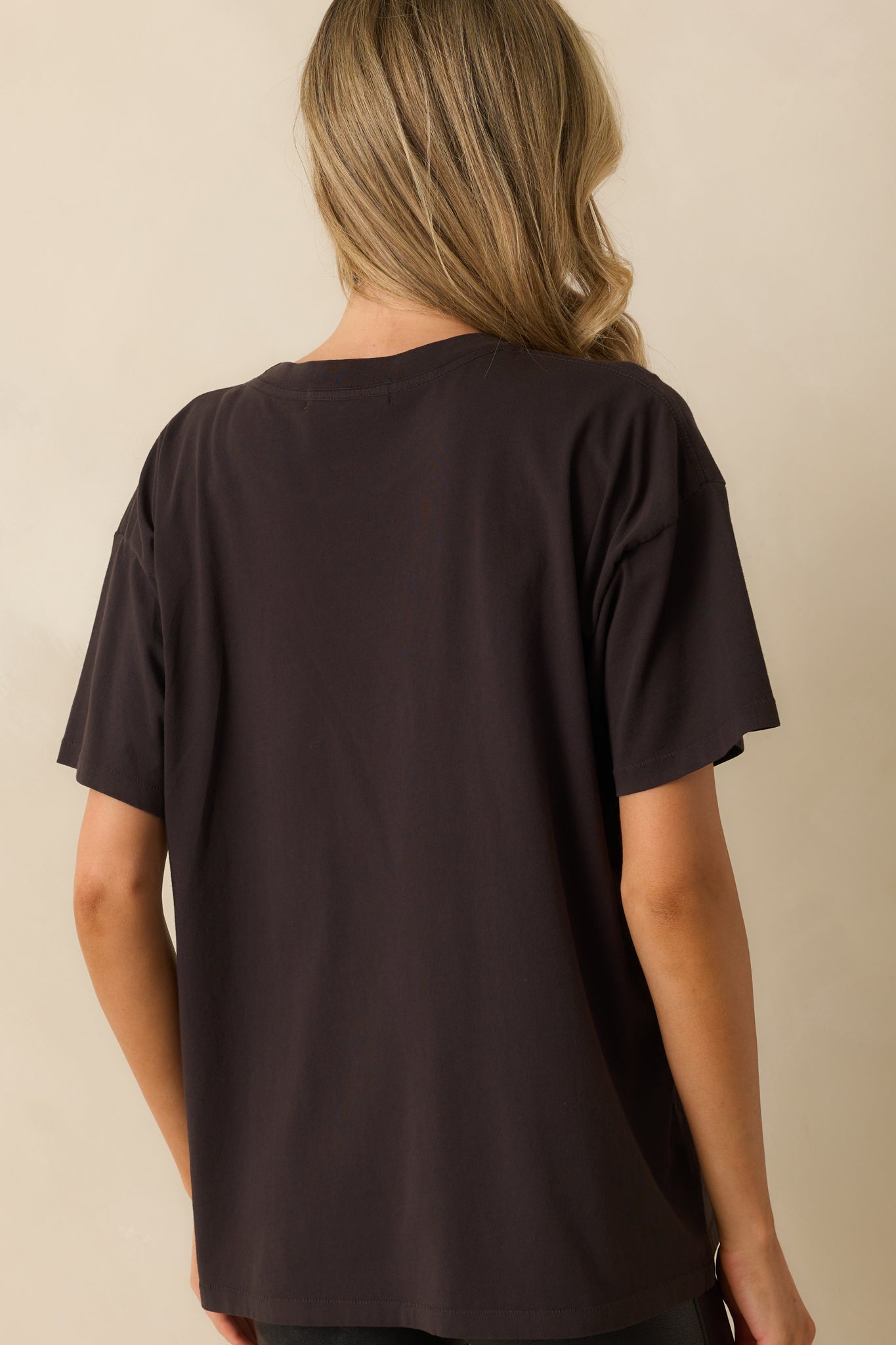 A back view of the tee showing the plain black fabric and oversized fit.