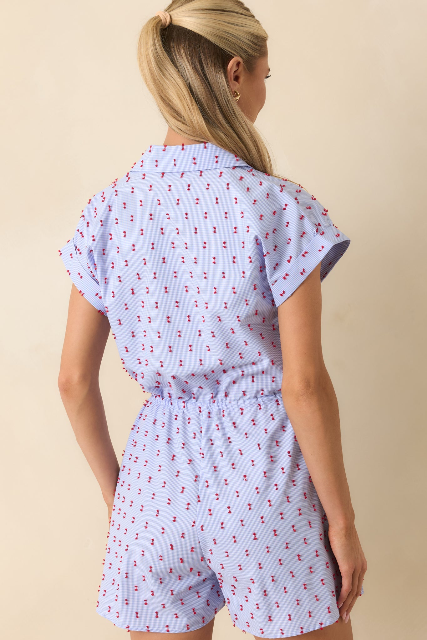 Back view of the blue gingham romper featuring a relaxed shorts silhouette, drawstring waist, and lightweight cotton fabric.