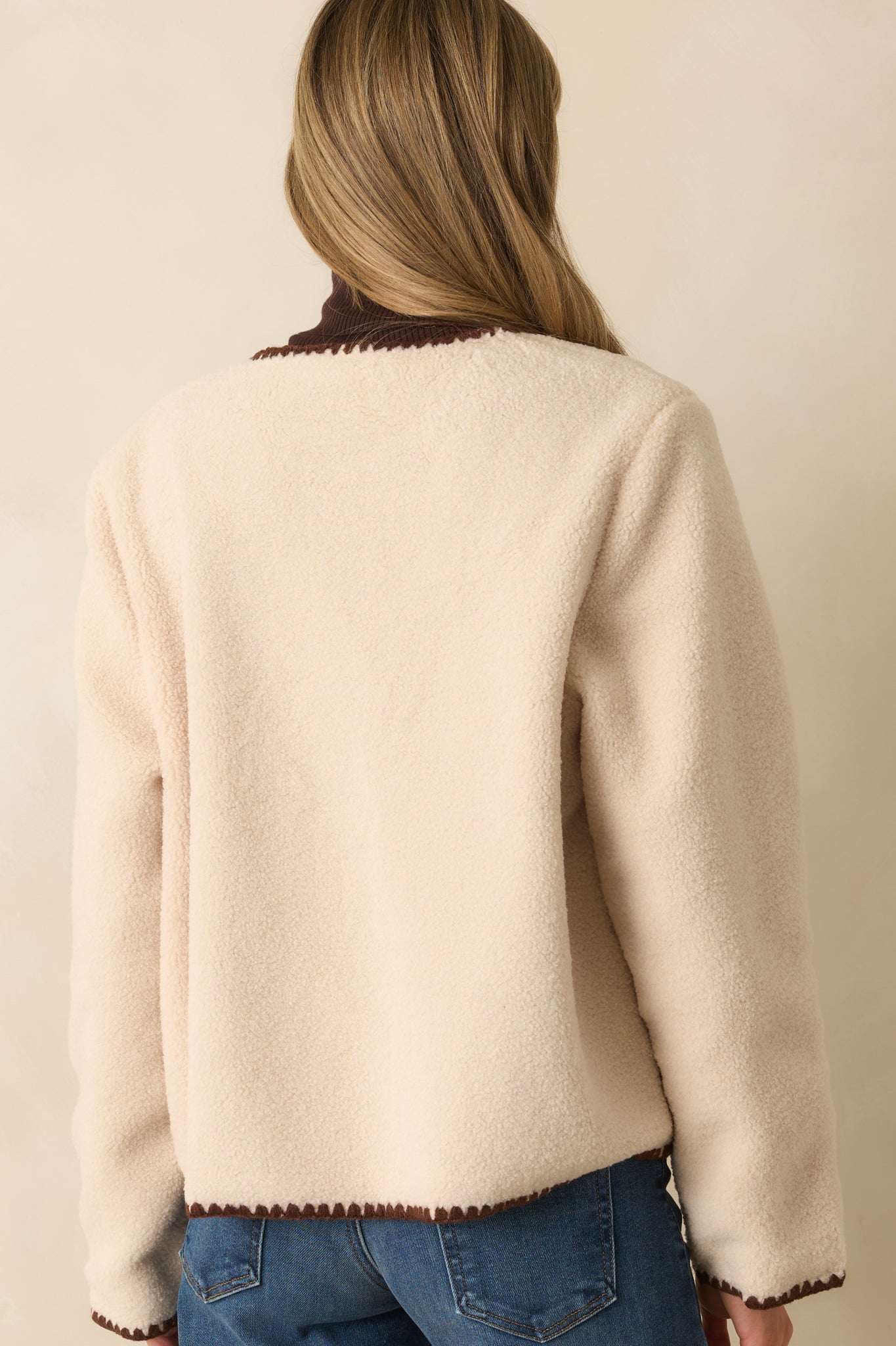 Rear view of the boxy ivory sherpa fleece jacket highlighting the smooth back with whipstitch trim along the seams.