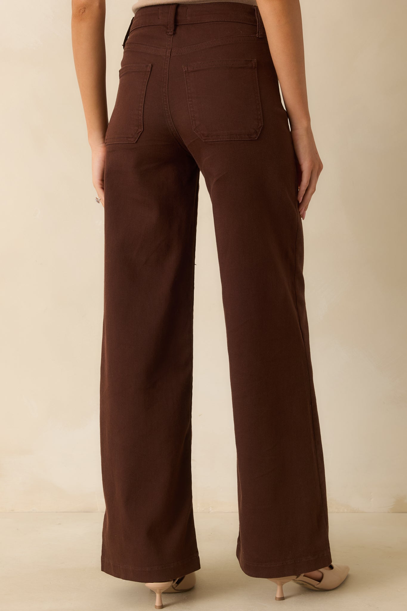 Back view of brown jeans showing functional back pockets and straight leg design.