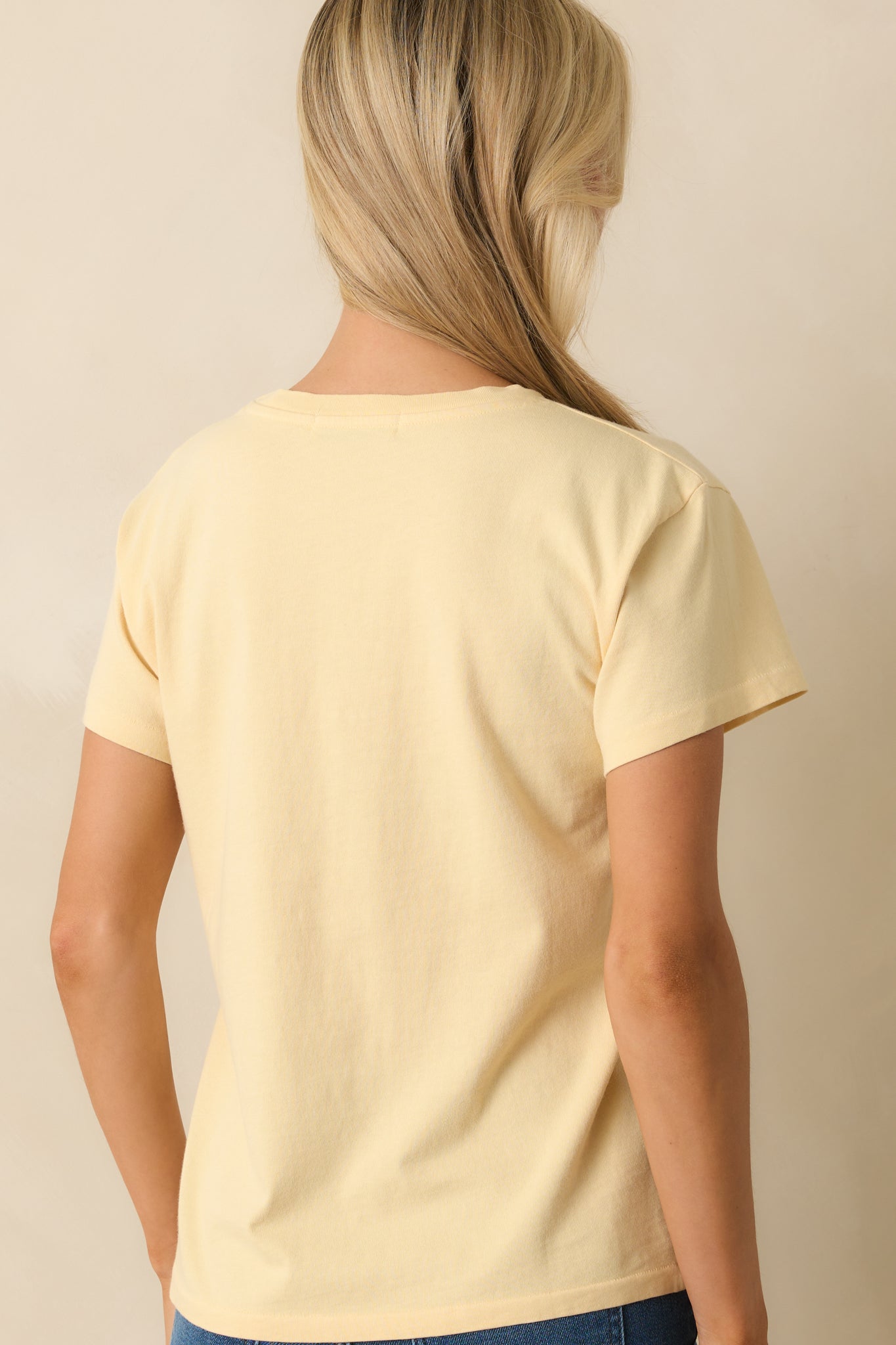 Rear view of the tee displaying the plain butter yellow back and relaxed silhouette.