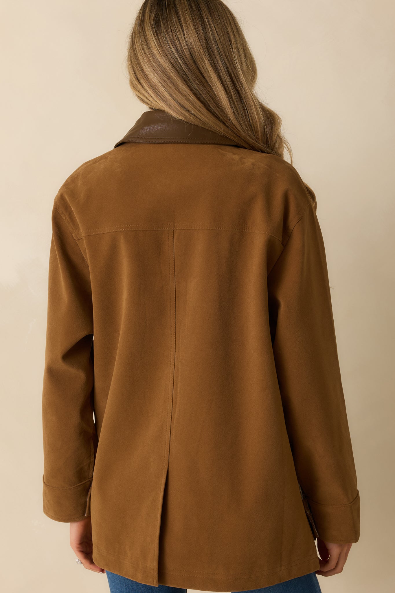 Back view of the jacket showing the smooth camel faux suede and structured back silhouette.