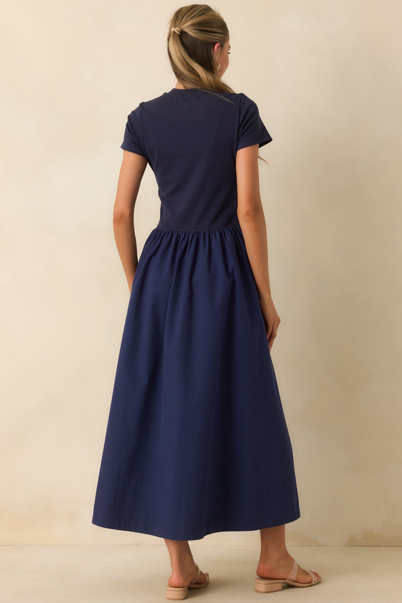 Back view of the cotton midi dress featuring a smooth fitted bodice and gathered full skirt silhouette.
