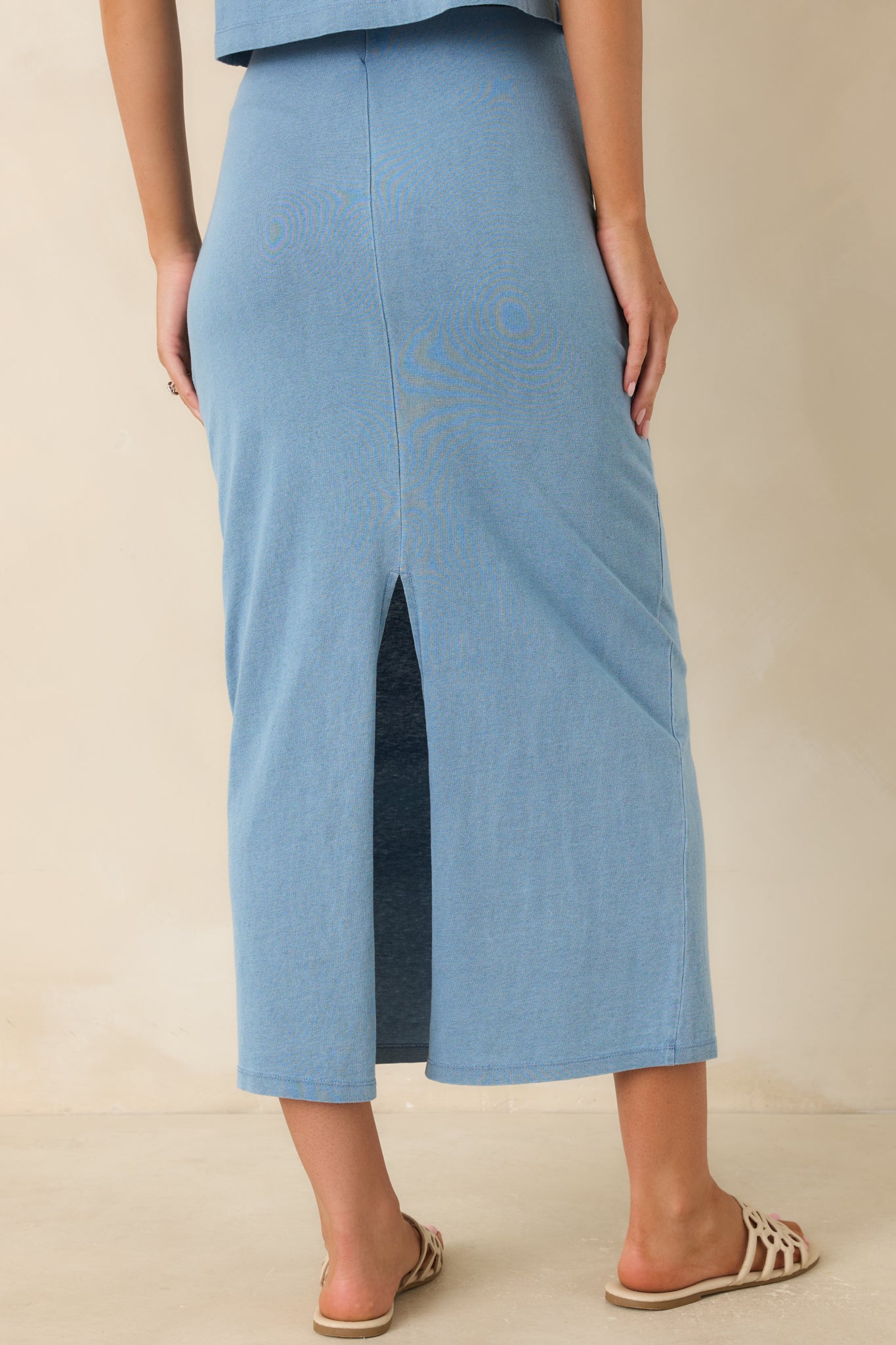 Back view of the denim-inspired knit midi skirt featuring a center back slit for movement.