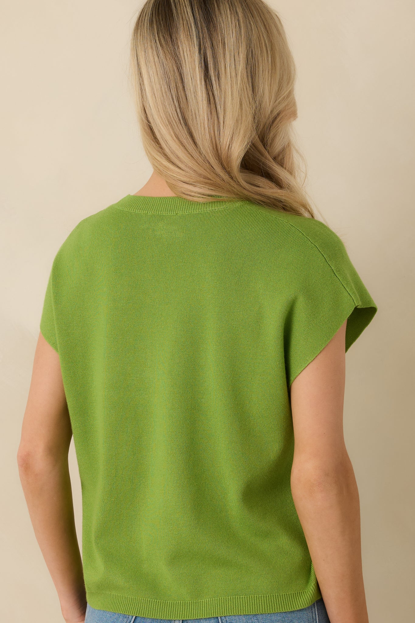 Back view of sweater displaying straight silhouette, relaxed short sleeves, and clean ribbed hem.