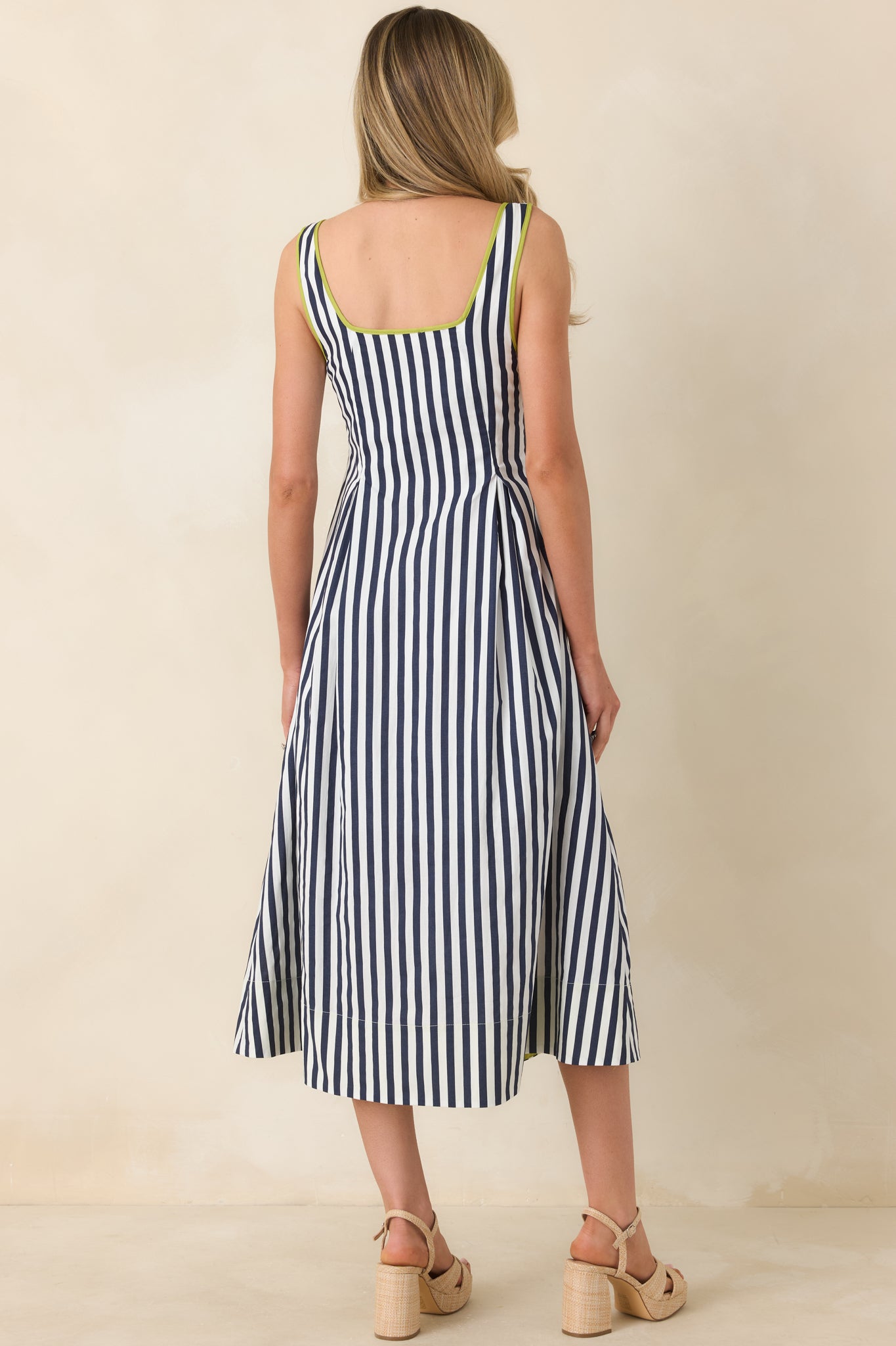 Back view of the midi dress displaying smooth back fabric, relaxed skirt, and concealed side zipper.