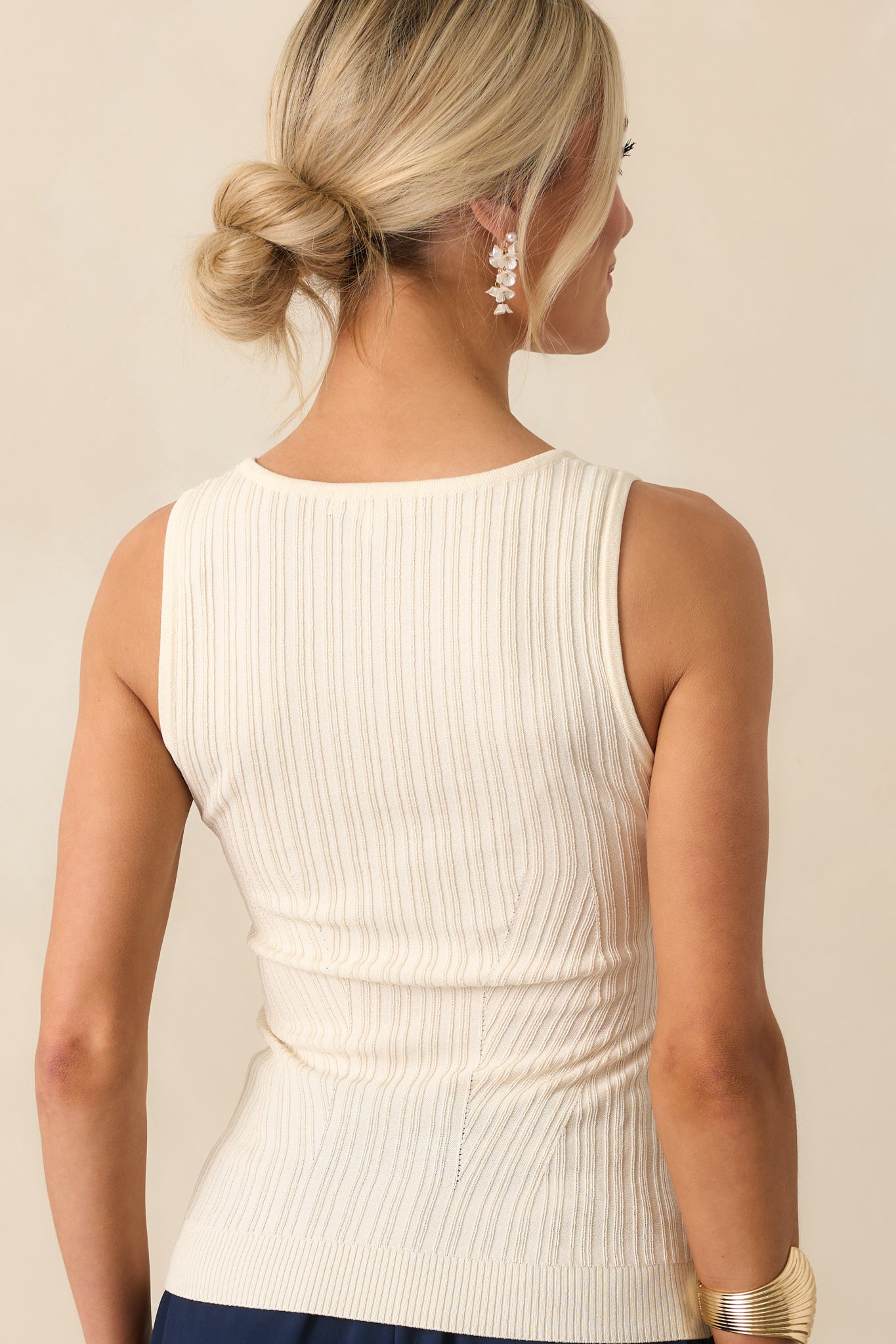 A back view of the top displaying the sleeveless cut and subtle taper of the slightly fitted design.